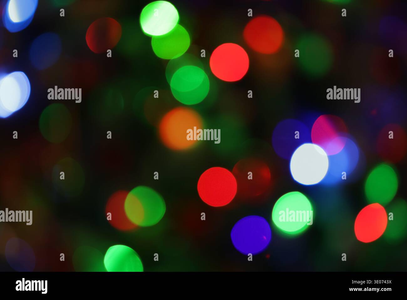 Une image floue de lumières colorées avec un cercle violet et vert au milieu. L'image a une humeur rêveuse et fantaisiste Banque D'Images