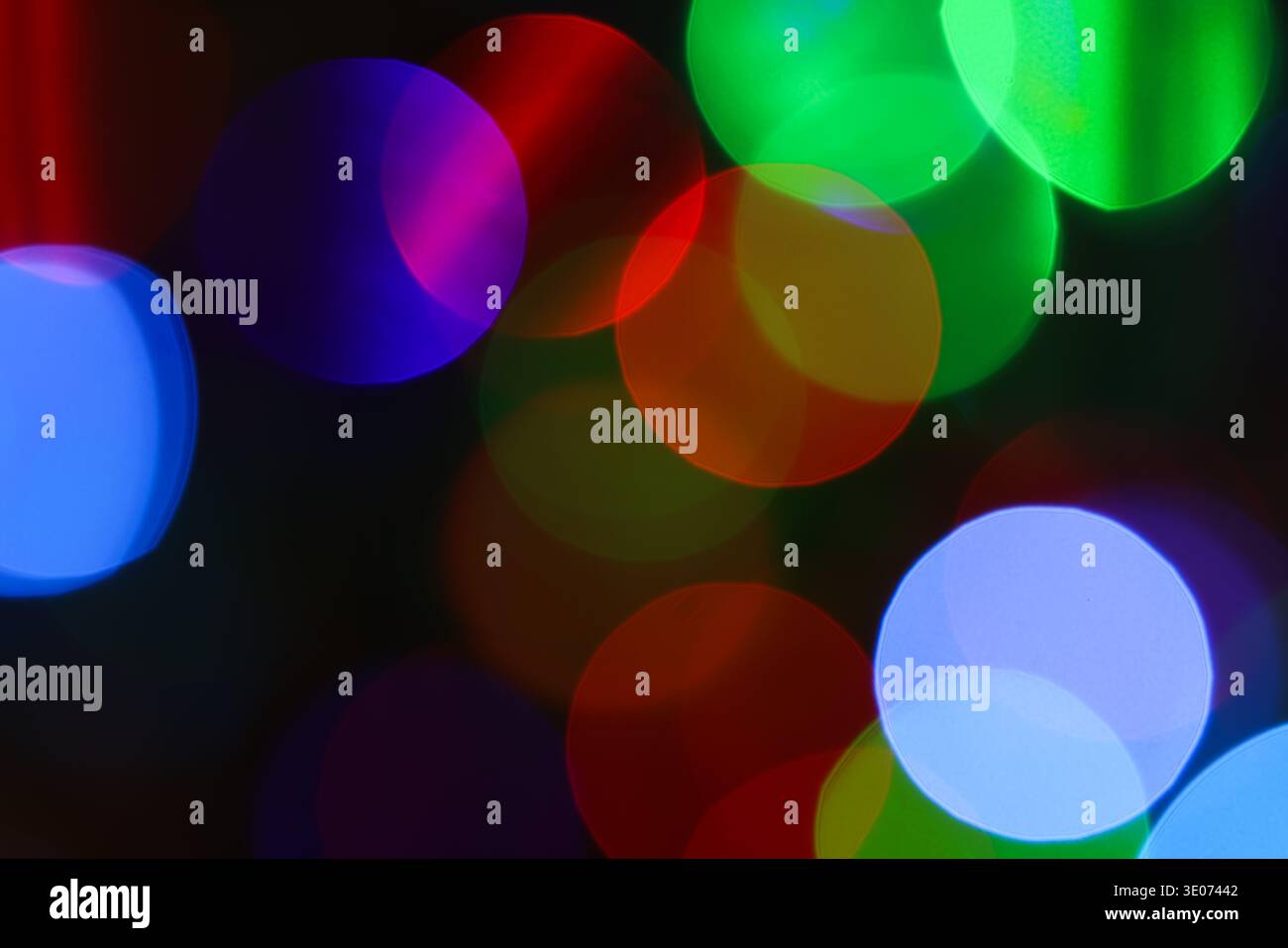 Une image floue de lumières colorées avec un cercle violet et vert au milieu. L'image a une humeur rêveuse et fantaisiste Banque D'Images