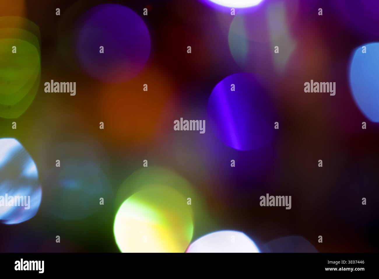 Une image floue de lumières colorées avec un cercle violet et vert au milieu. L'image a une humeur rêveuse et fantaisiste Banque D'Images
