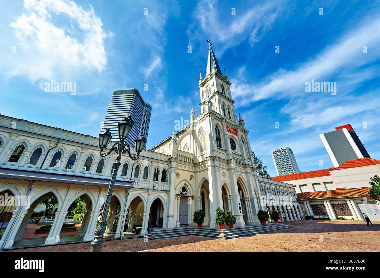 Les gens traversent Chijmes Convent et Caldwell House à Singapour sous un ciel dégagé. La zone montre les bâtiments et l'histoire. Banque D'Images