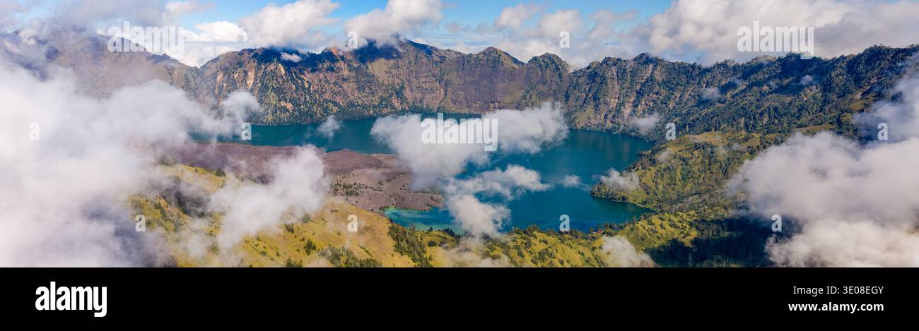 Large vue panoramique sur un étonnant lac de cratère volcanique partiellement caché par des nuages blancs Banque D'Images