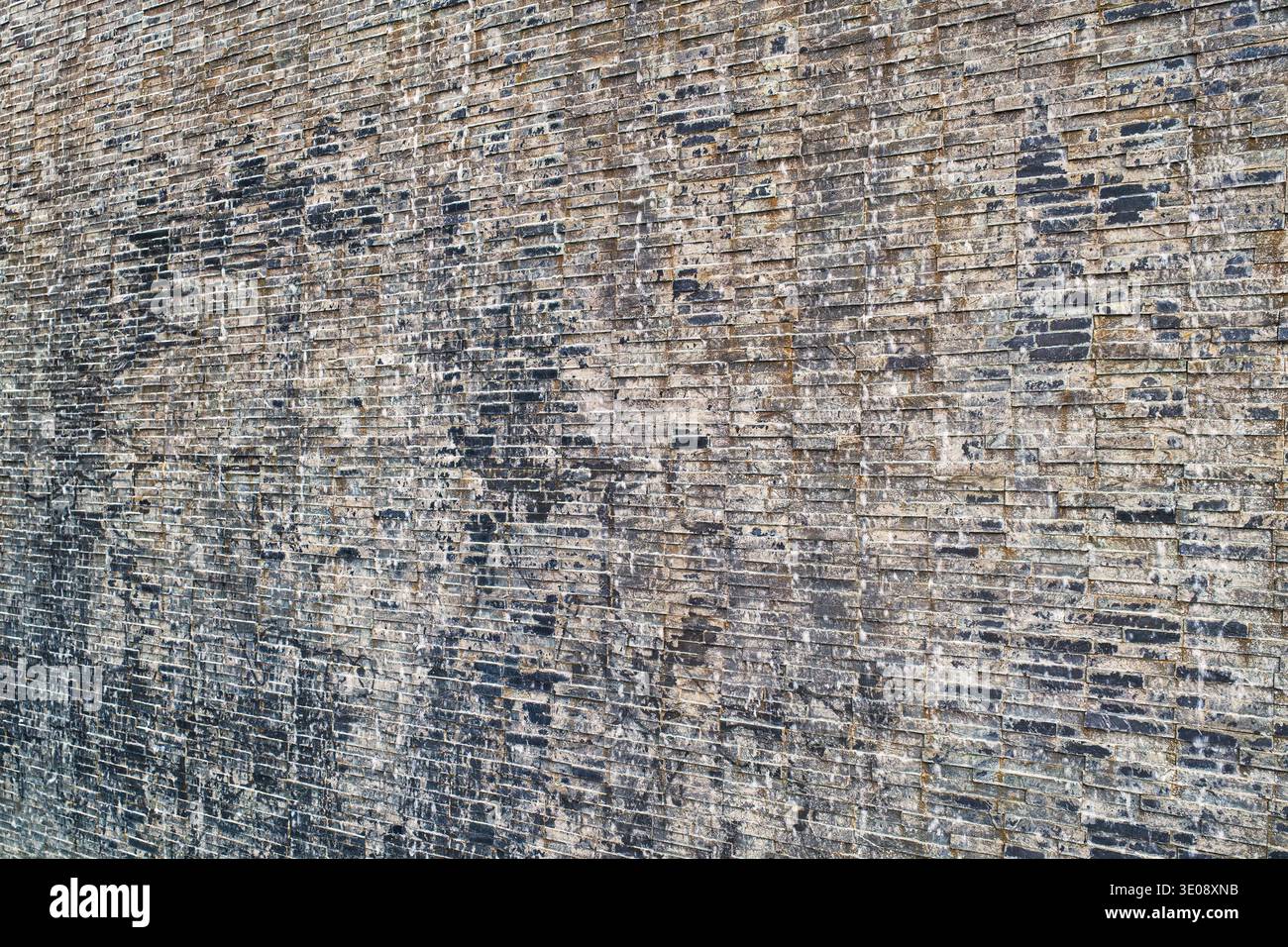 Gros plan détaillé d'un mur de briques altérées, présentant diverses textures et motifs uniques. Cette image capture le charme rustique de l'architecte âgé Banque D'Images