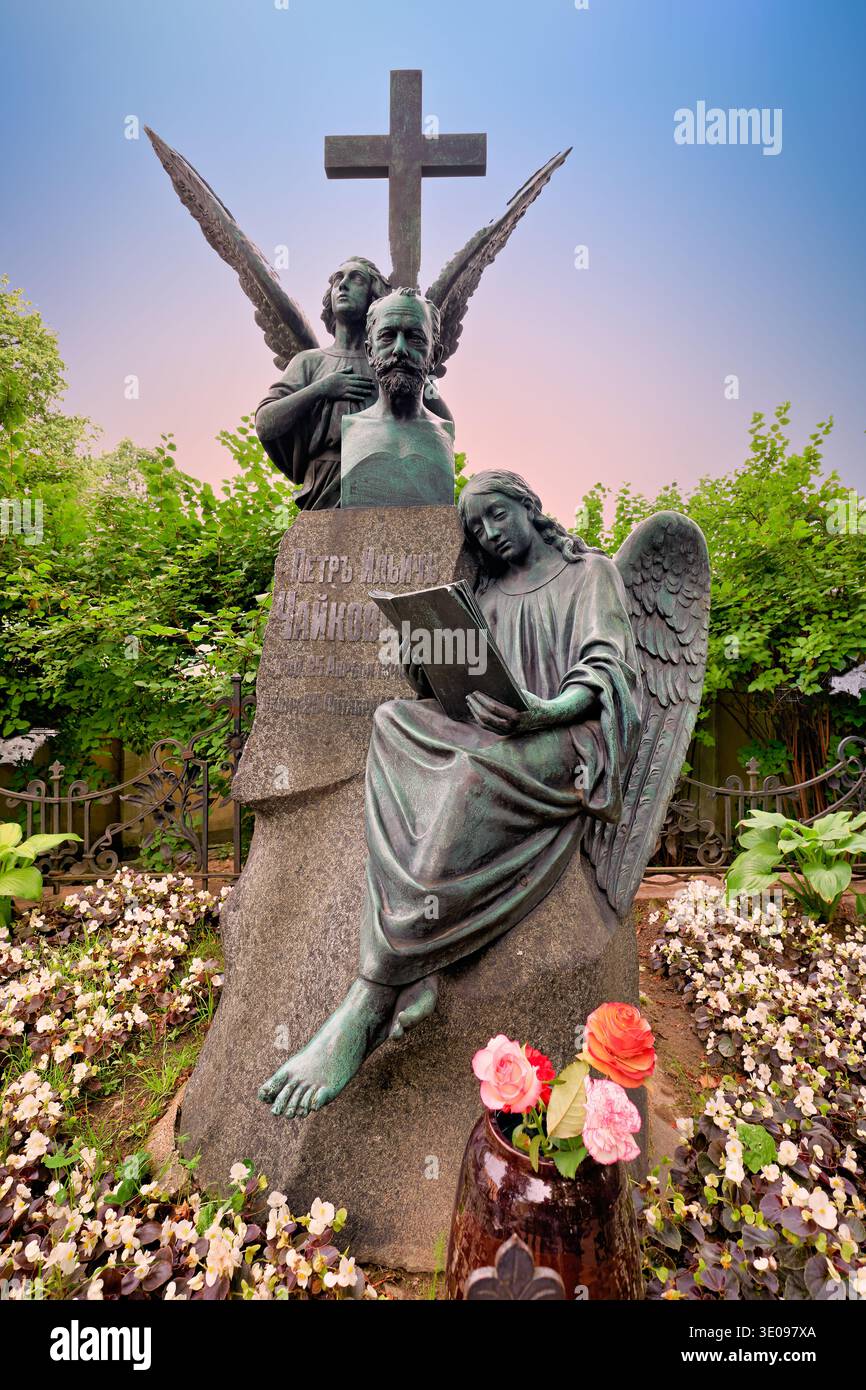 La tombe de Fyodor Dostoïevski montre une statue d'un ange lisant au milieu de fleurs et de verdure dans le cimetière de Tikhvin, Saint-Pétersbourg, Russie. Banque D'Images