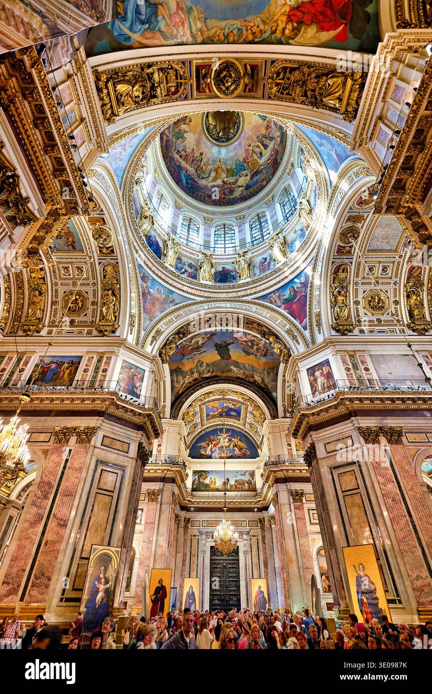 Les visiteurs se rassemblent à l'intérieur de la cathédrale d'Isaac à Pétersbourg, admirant la grande architecture et les œuvres d'art détaillées sur les plafonds et les murs. Banque D'Images