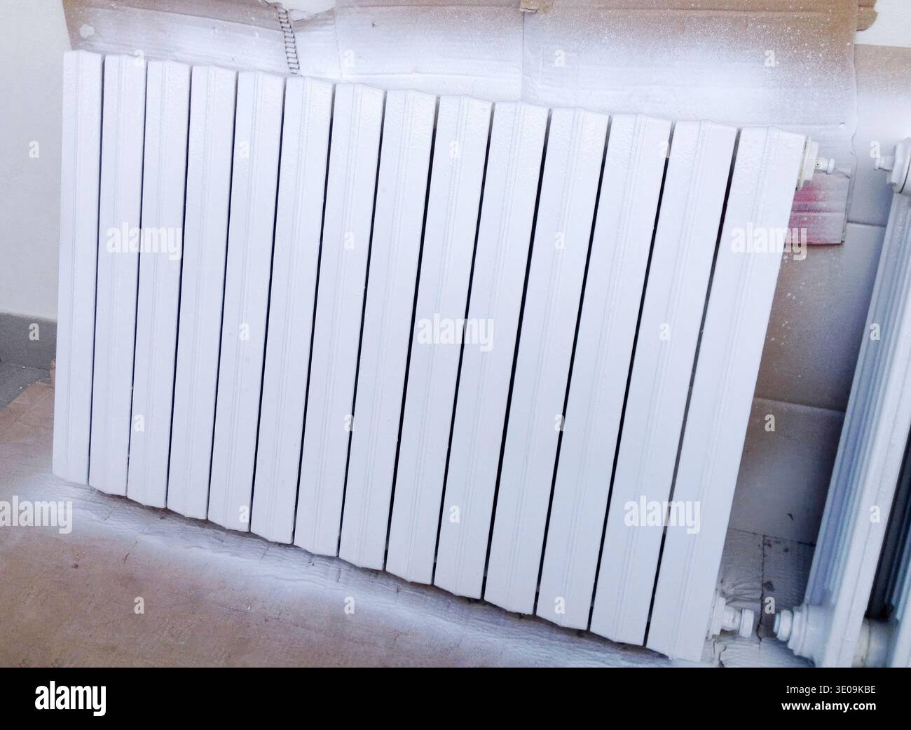 Radiateur en fonte blanche séchant après avoir été peint avec de la peinture émaillée blanche lors d'un projet de rénovation de la maison Banque D'Images