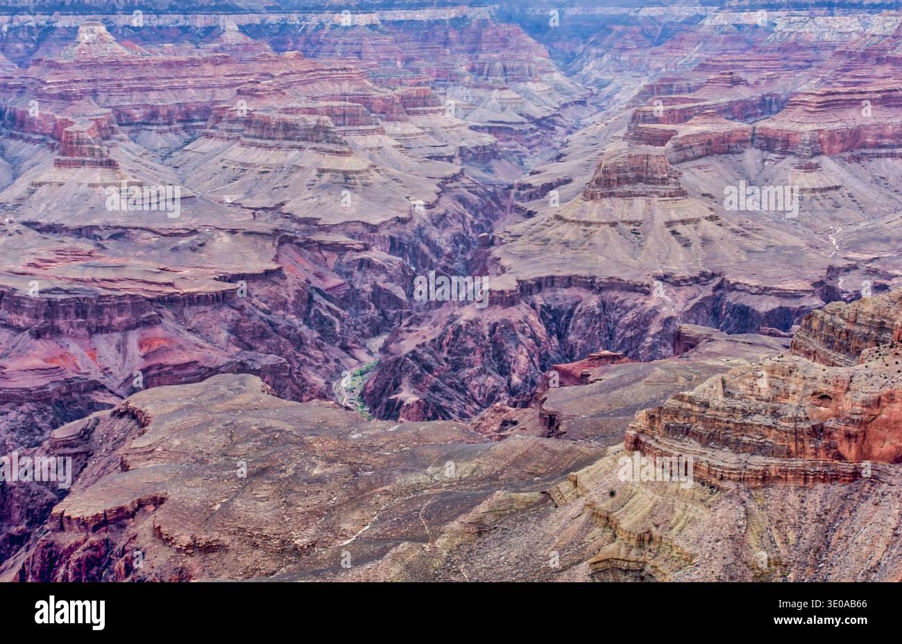 Un vaste canyon traversé par une rivière. Le canyon est rempli de rochers et a un aspect rocheux et aride. Le ciel est bleu et le soleil est tibia Banque D'Images