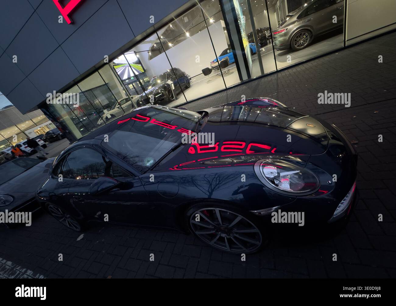 13.11.2025, Allemagne, Brême, Brême - reflet du logo Porsche illuminé sur une nouvelle Porsche, à l'extérieur de la concession Porsche CEN Banque D'Images