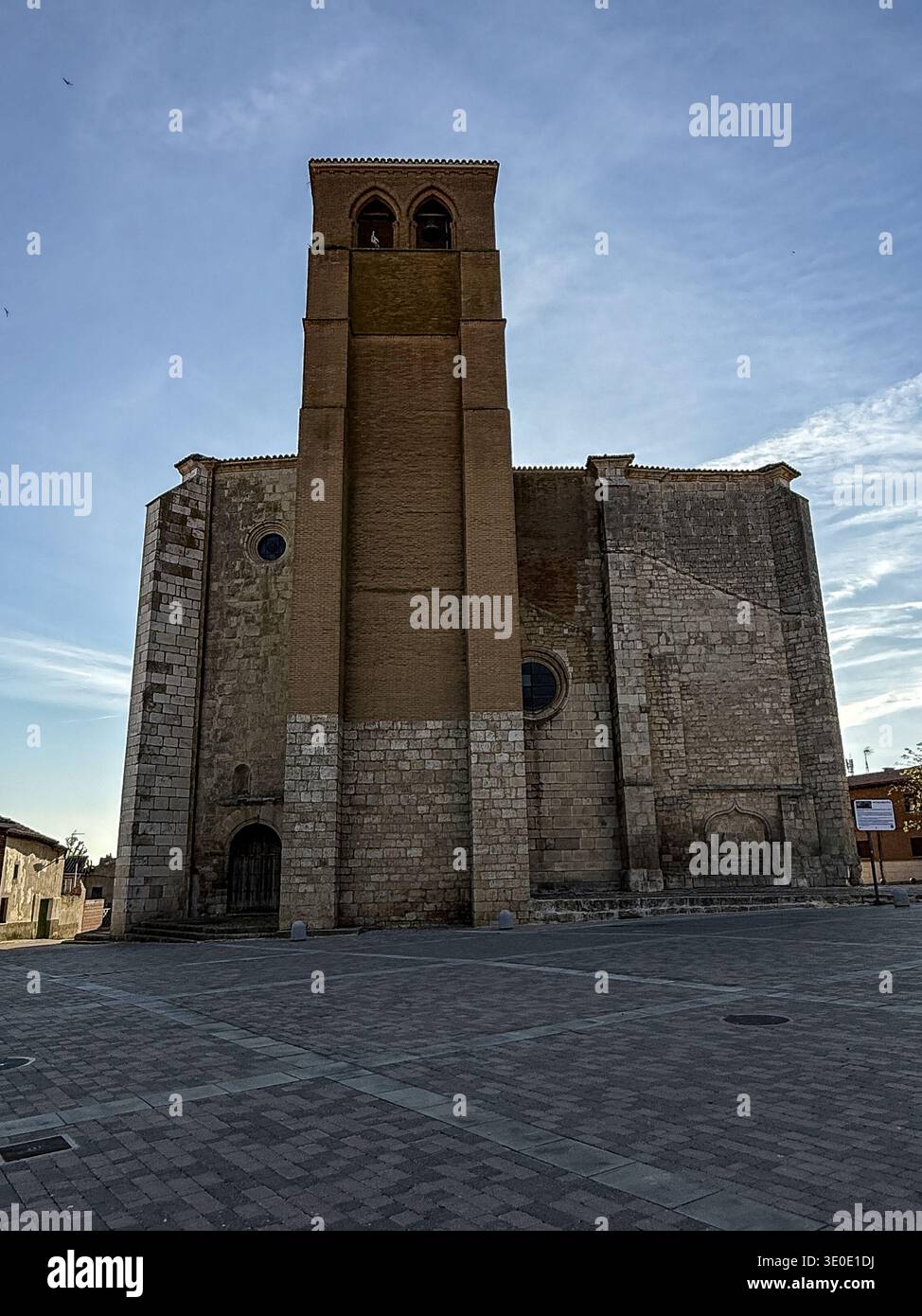 Église Santa Eugenia avec clocher en brique et abside en pierre face à la place principale de Becerril de Campos Banque D'Images