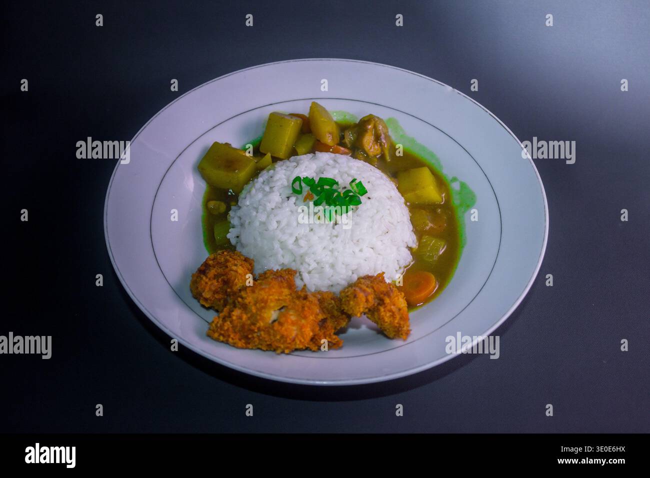Délicieux repas fait maison avec riz blanc moelleux, poulet frit pané croquant et curry de légumes salé avec pommes de terre et carottes. Nourriture réconfortante Banque D'Images