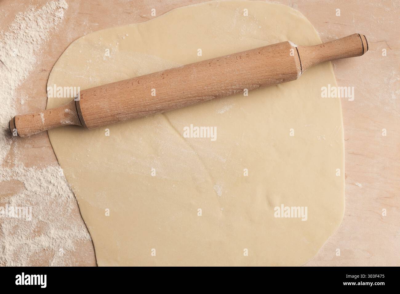 Pâte roulée avec rouleau à pâtisserie sur fond en bois, vue de dessus Banque D'Images