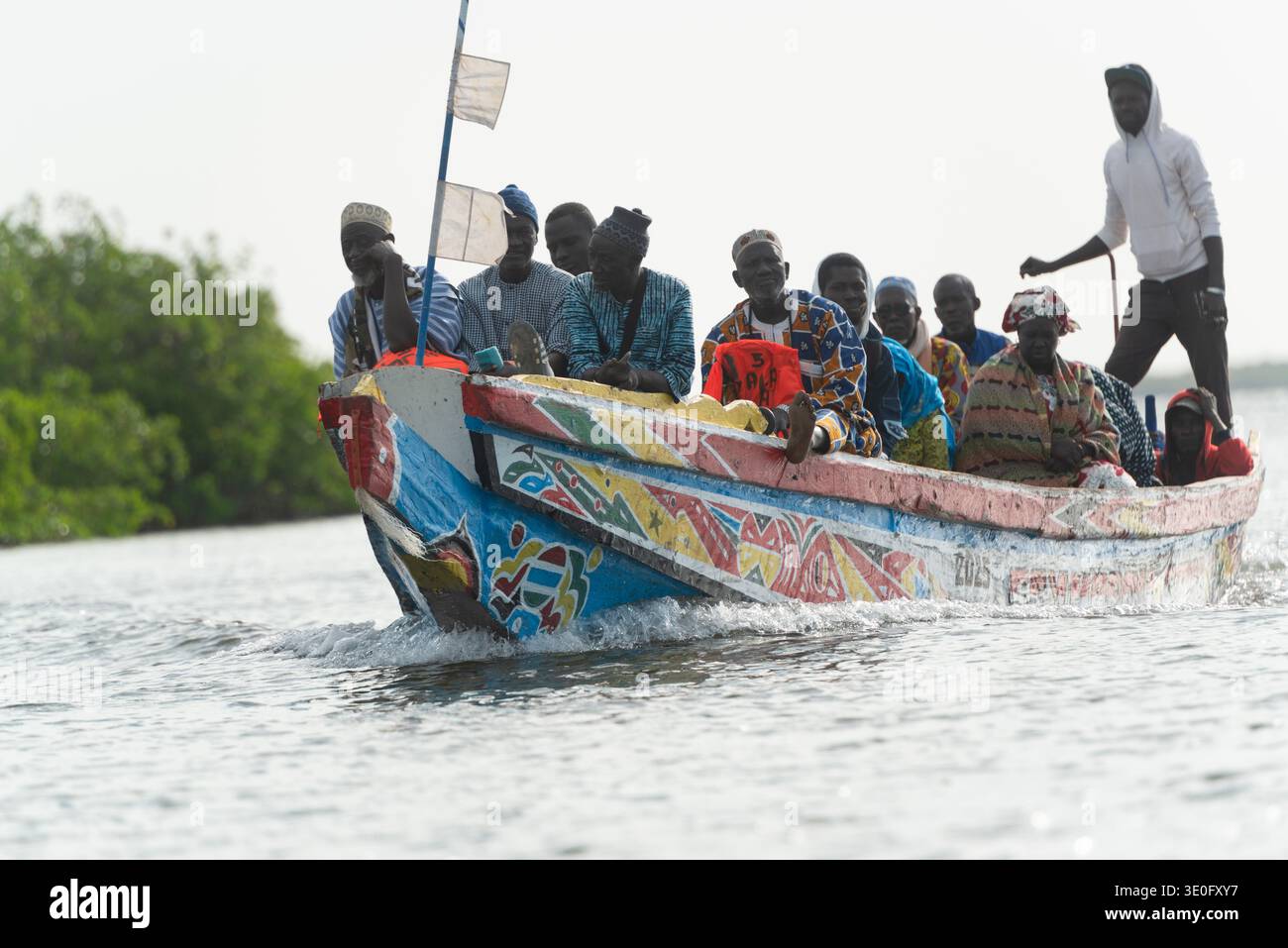 Transport local par pirogue avec passagers dans le delta du Siné-Saloum au Sénégal Banque D'Images