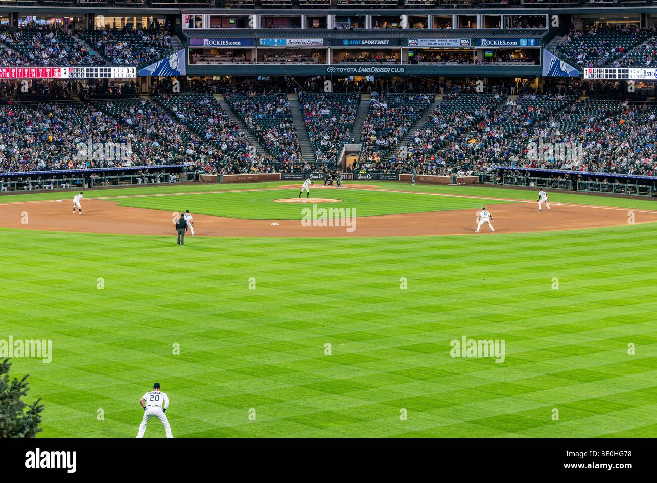 Match de baseball nocturne dans un stade rempli avec des joueurs sur le terrain et des fans dans des tribunes Banque D'Images