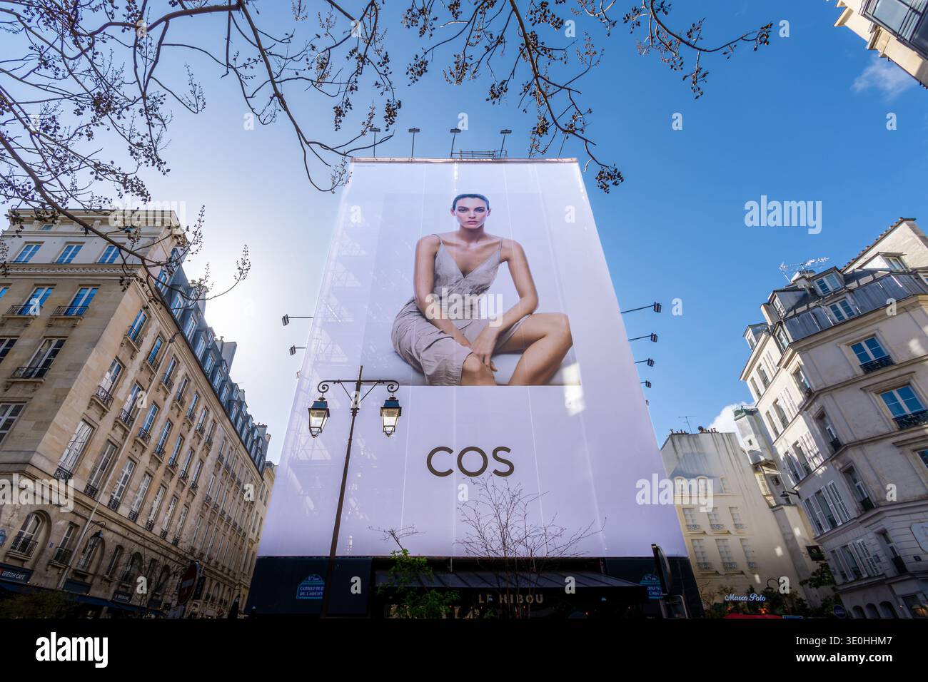 Panneau publicitaire pour COS (Collection of style), une marque de mode du groupe H and M, couvrant la façade d'un immeuble à Paris, France Banque D'Images
