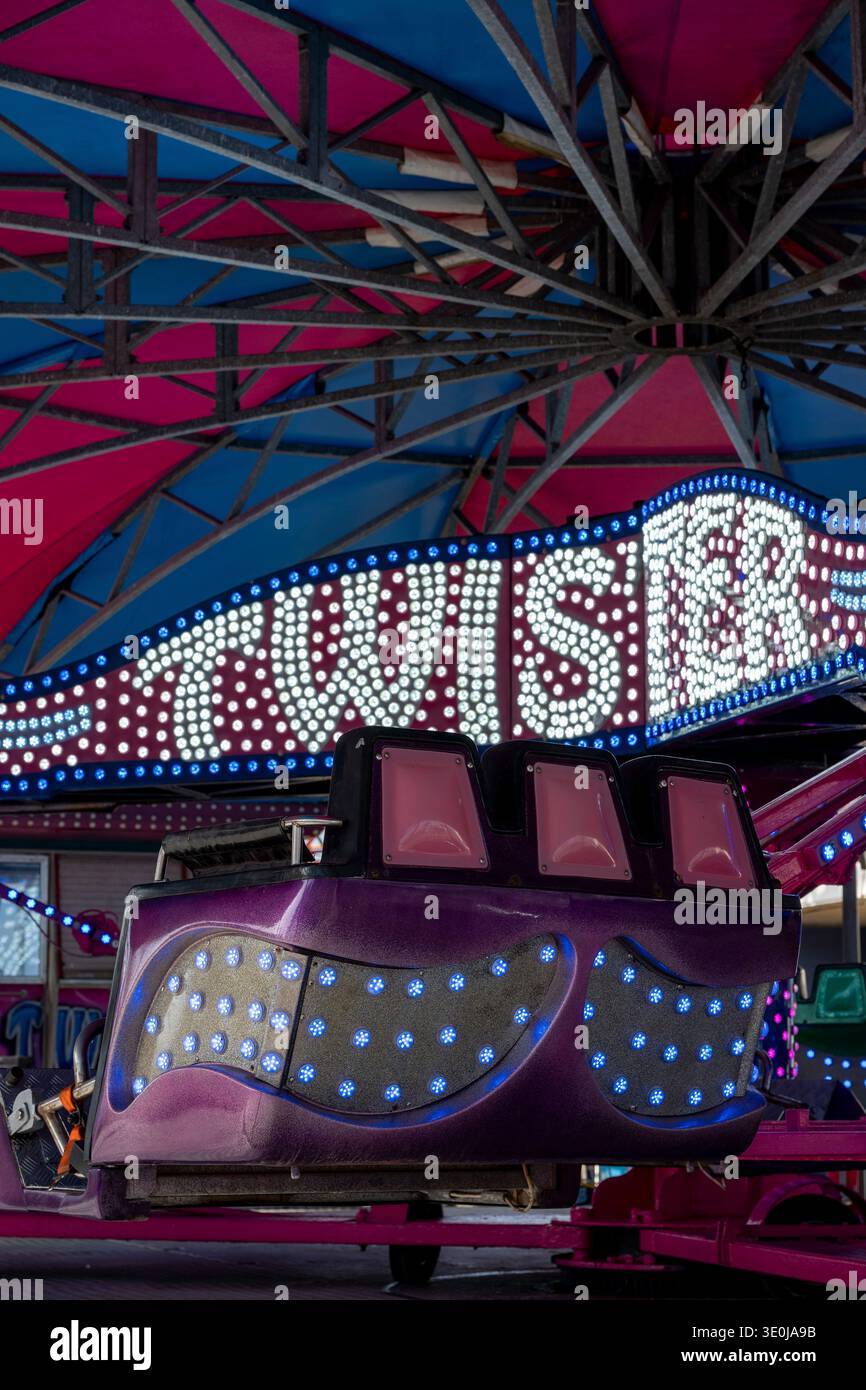 Tour de foire Twister avec des lumières vives et des œuvres colorées de foire funfair, tour de foire Waltzer à Southsea, Portsmouth Royaume-Uni Banque D'Images