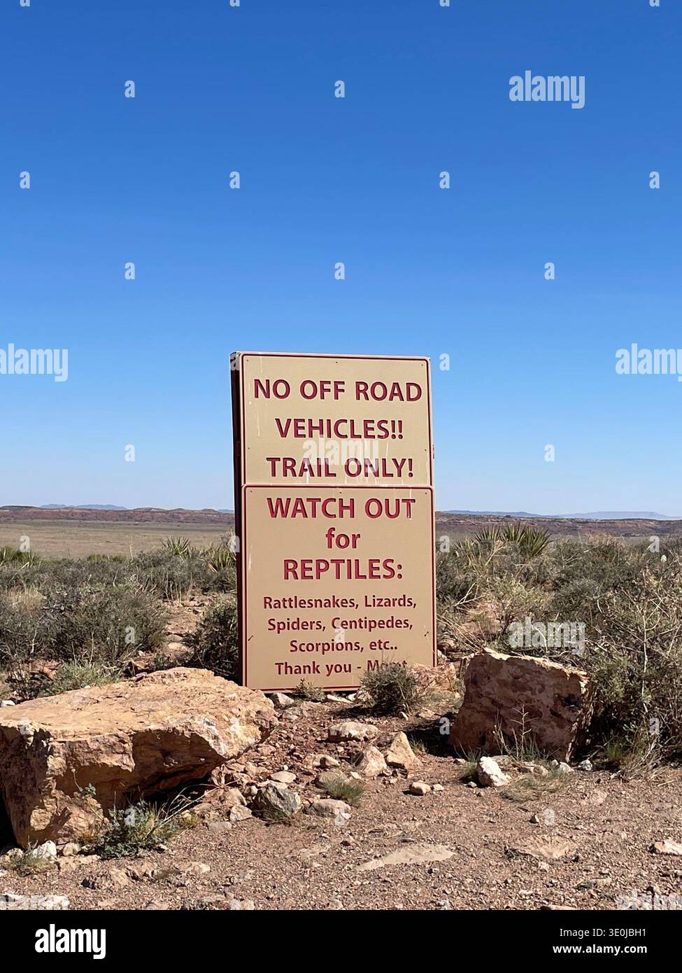 Panneau d'avertissement dans le paysage désertique conseillant sur les reptiles et les restrictions hors route dans le sud-ouest des États-Unis. - Image de stock capturée avec un smartphone