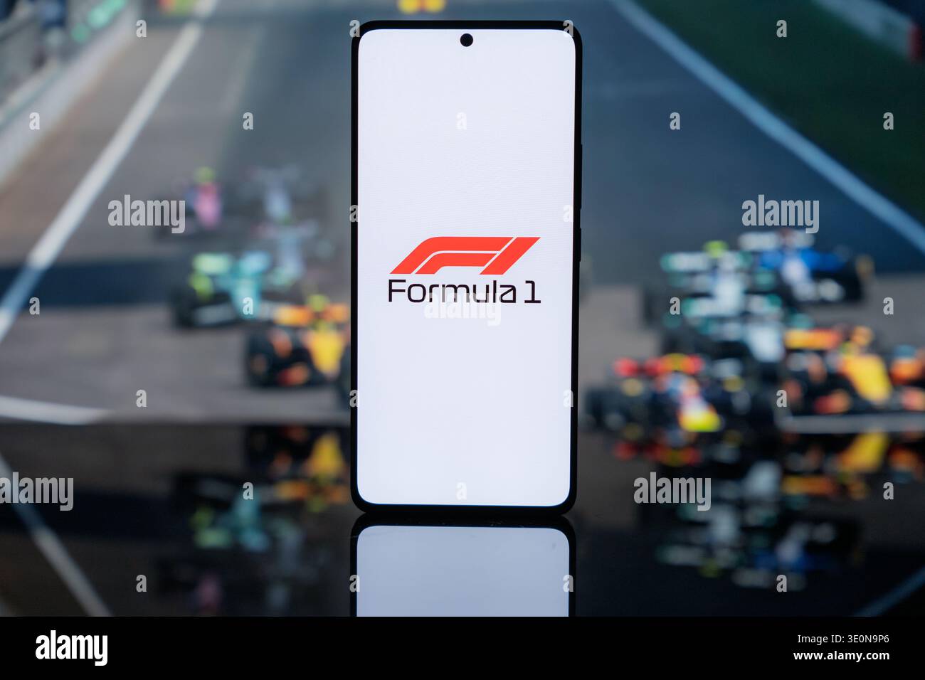 Le logo officiel de la formule 1 sur un écran blanc, sur fond flou de voitures de course F1 sur une piste, représentant le sport automobile professionnel Banque D'Images