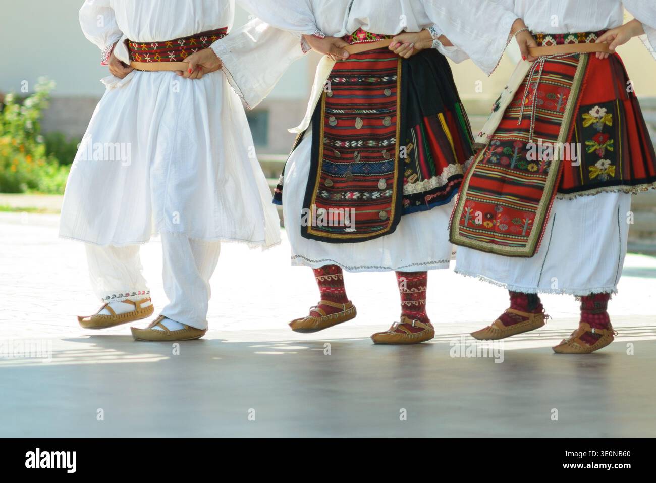 Vêtements traditionnels vlach en Bulgarie avec tabliers tissés, vêtements blancs, chaussettes à motifs, ceintures et chaussures en cuir. Banque D'Images