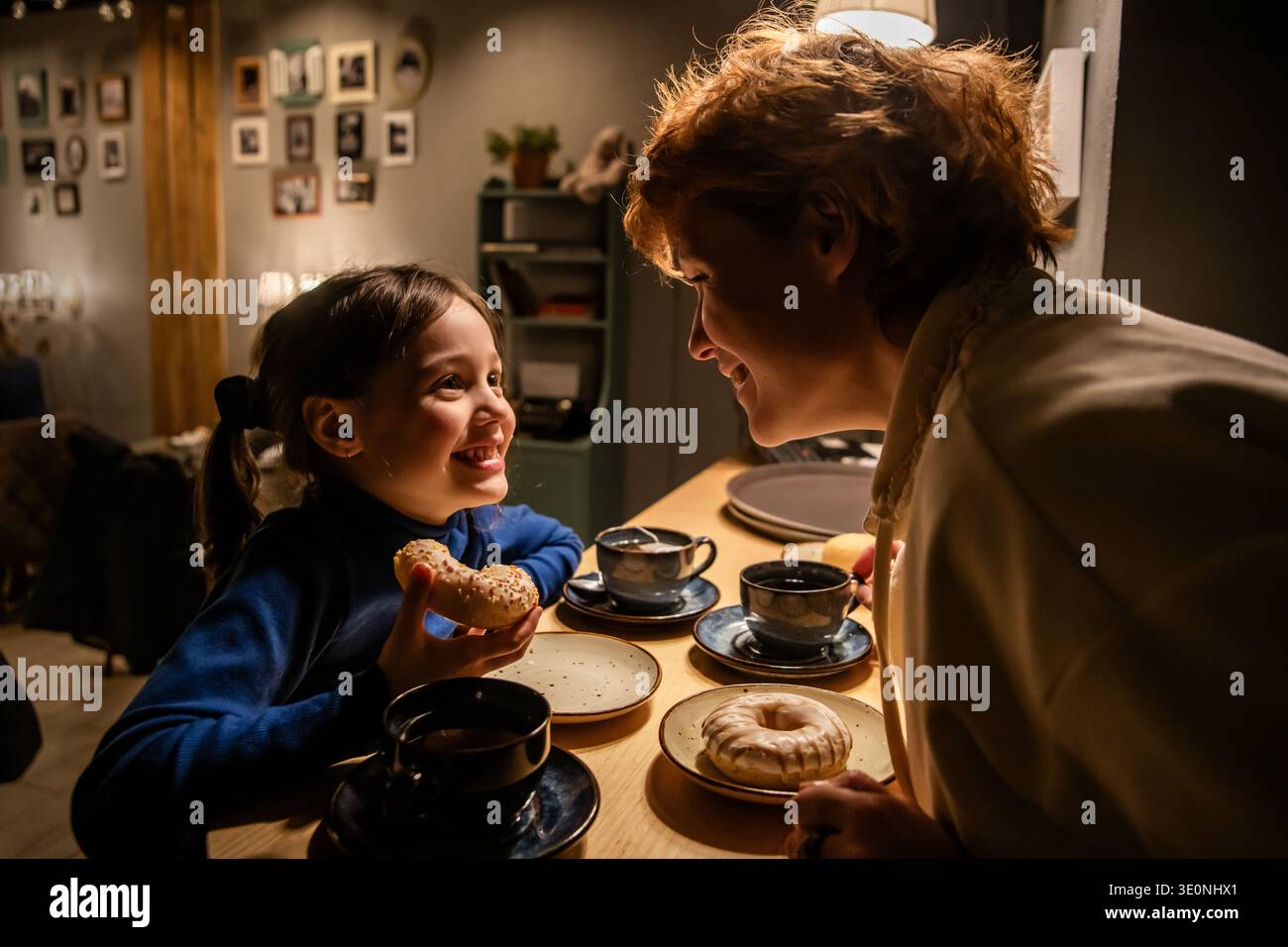 Parent souriant et enfant passant du temps ensemble dans un restaurant confortable. Banque D'Images