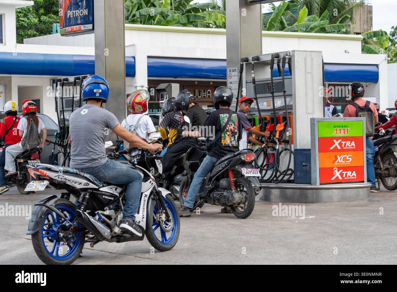 Des motocyclistes font la queue à la station-service Petron qui fait le plein de carburant à Cebu Philippines, dans un contexte de hausse des prix mondiaux du pétrole et de volatilité du marché de l'énergie. Banque D'Images