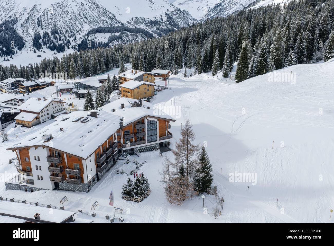 Aérien des chalets et hôtels de Lech et Oberlech par forêt de pins Banque D'Images