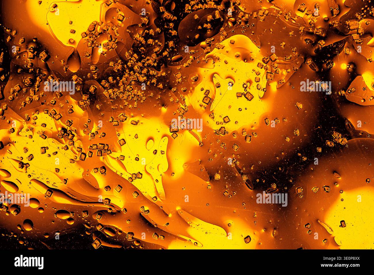 Macro photographie abstraite de liquide doré et de bulles d'huile créant une texture métallique luxueuse avec des formes organiques et une lueur ambre chaude. Banque D'Images