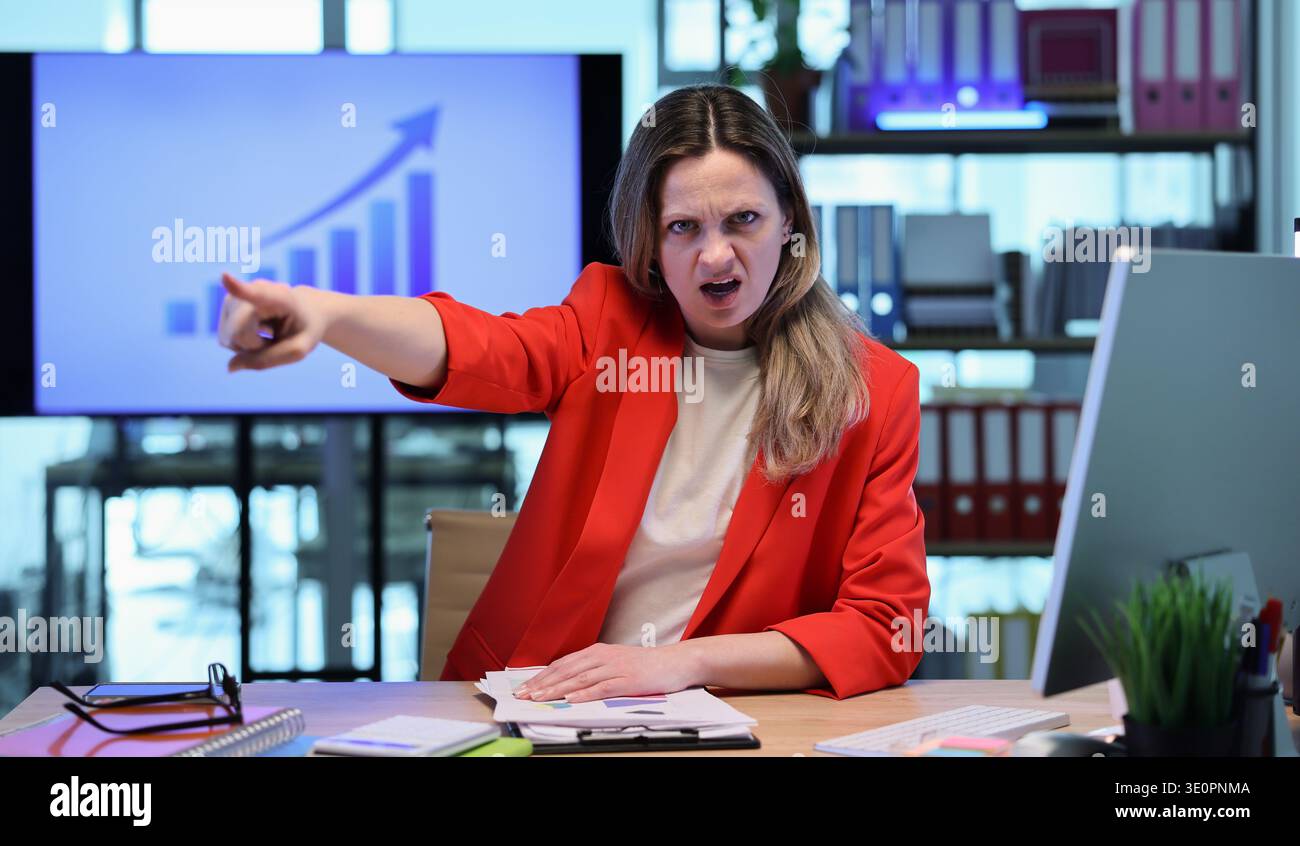 Femme d'affaires audacieuse délivrant passionnément un message puissant dans son espace de travail moderne de bureau lors d'une réunion stratégique Banque D'Images