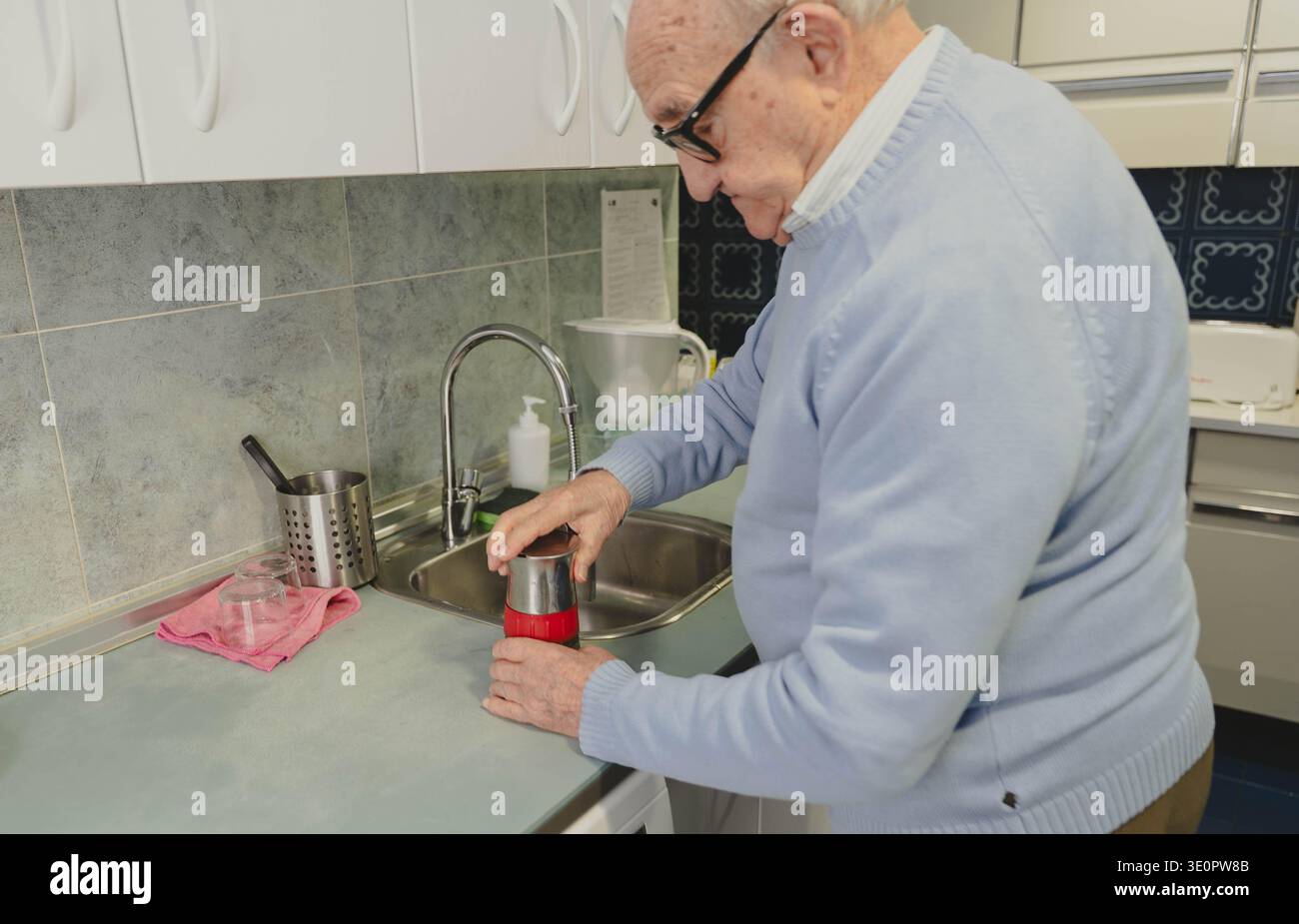 Homme senior préparant un pot de moka dans sa cuisine Banque D'Images
