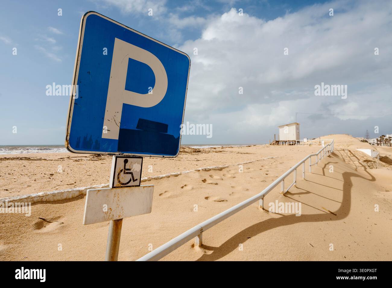 Une tempête hivernale dramatique a balayé la plage de Faro au Portugal, laissant le paysage transformé. Cette scène capture un parking couvert de sable Banque D'Images
