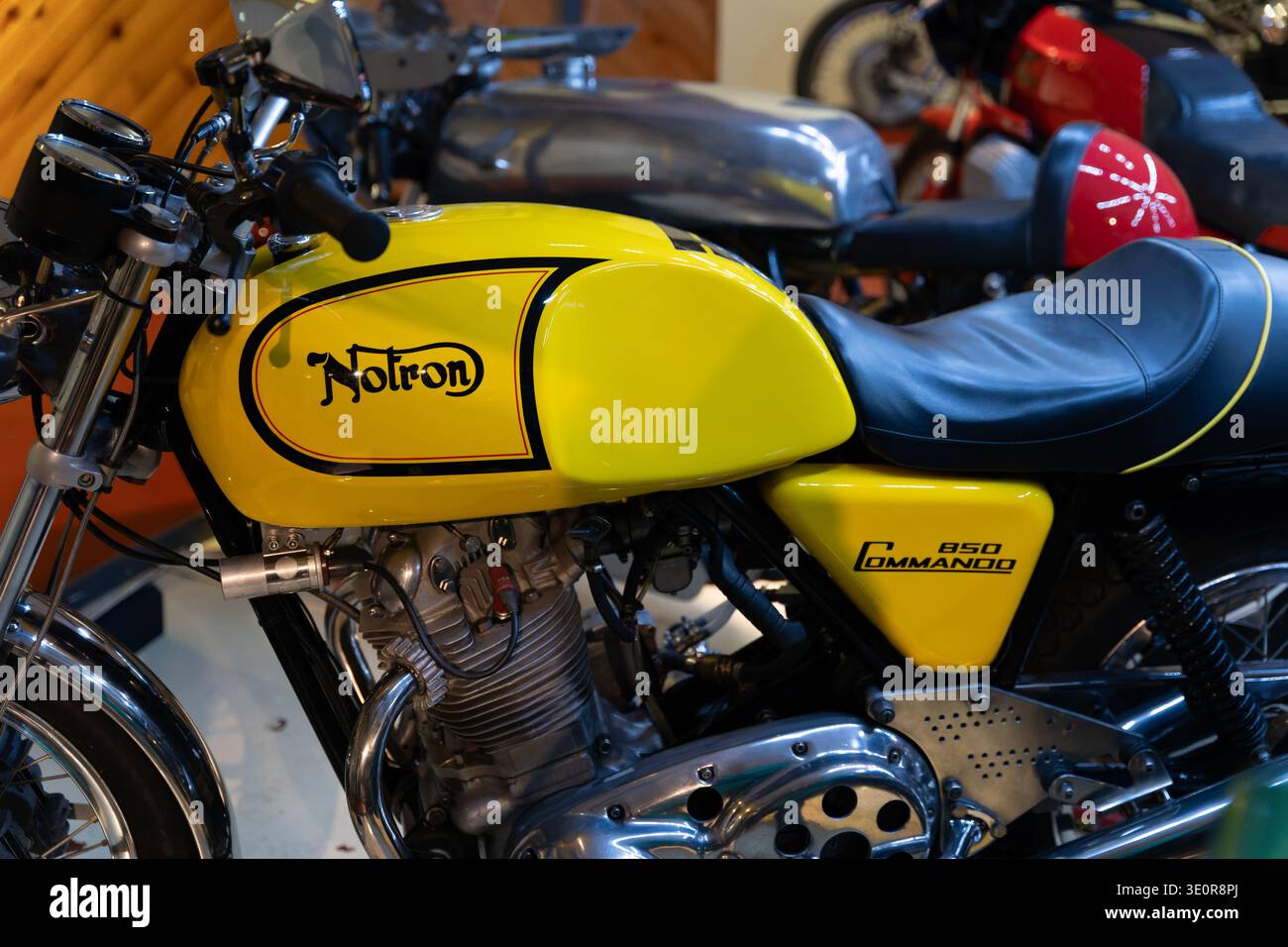 Moto britannique classique Norton 850 Commando jaune exposée, avec emblème de réservoir emblématique et détails chromés du moteur Banque D'Images