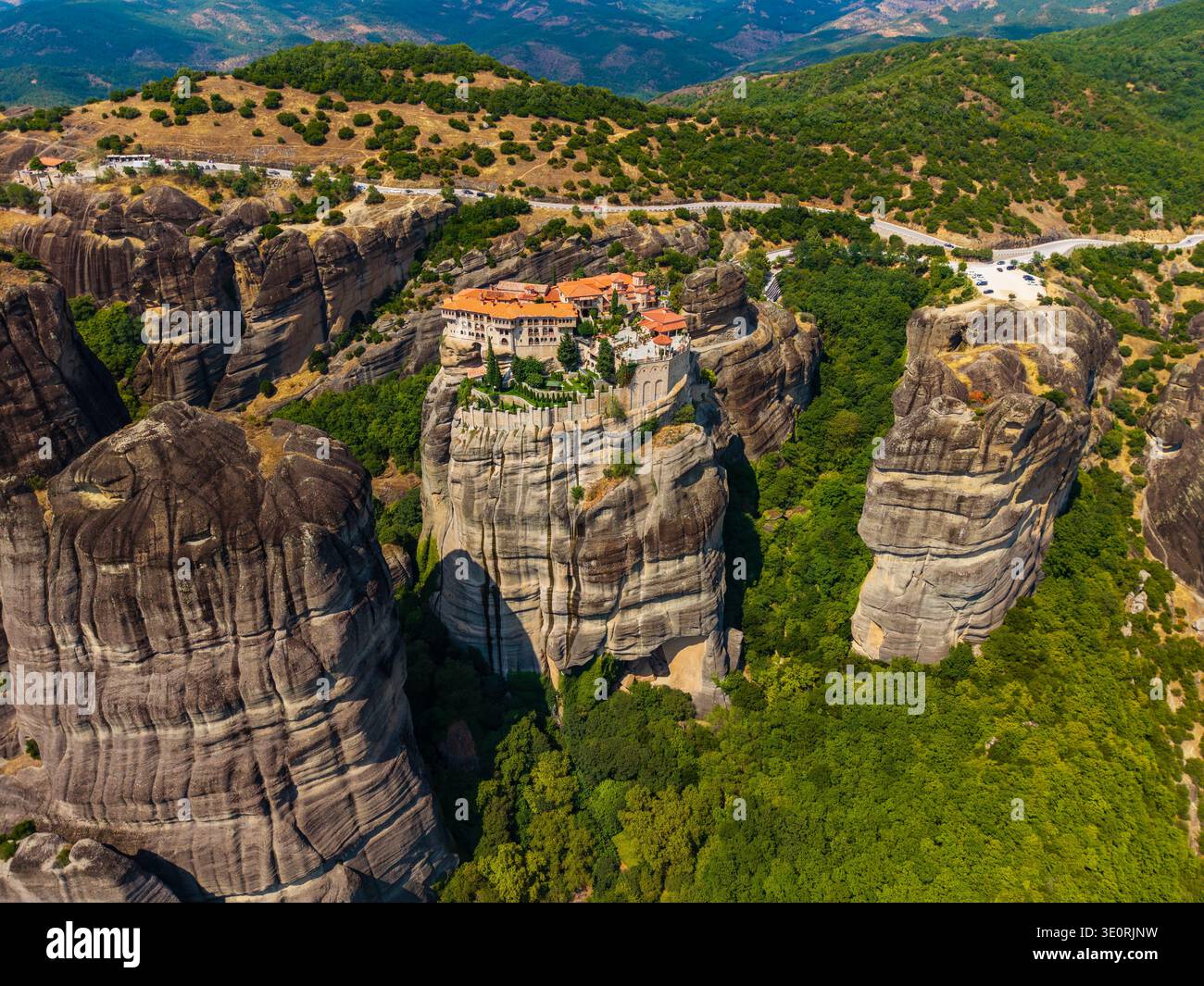 Vue aérienne du monastère de Rousanou perché au sommet d'une formation rocheuse imposante au milieu de paysages verdoyants, Météores, Trikala, Grèce. Banque D'Images