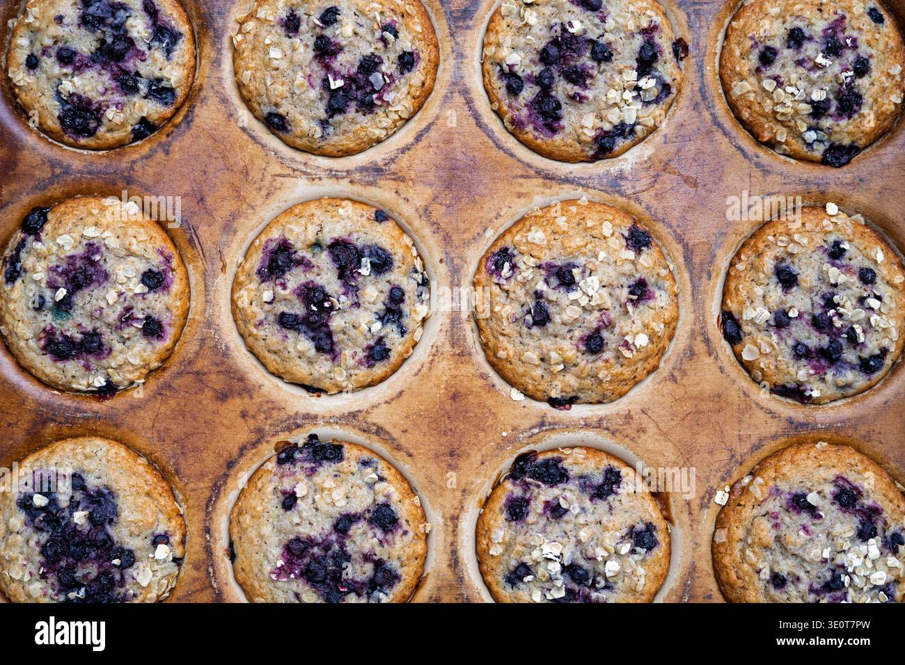 Muffins à l'avoine aux myrtilles fraîchement cuits dans une boîte à muffins vintage Banque D'Images