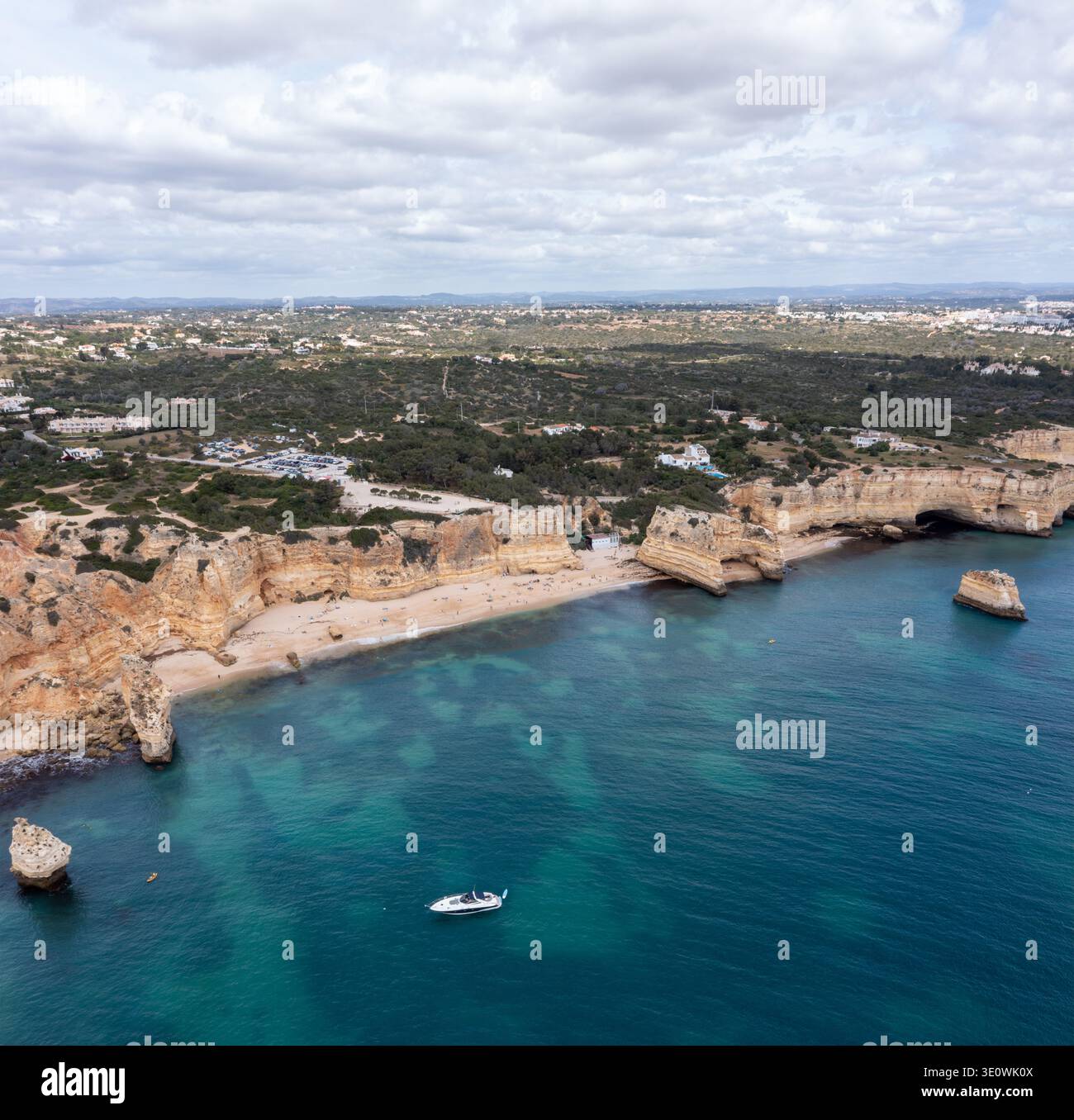 Cette vaste photographie aérienne capture les légendaires falaises de calcaire doré et les eaux turquoises cristallines de la côte de l'Algarve. Un whi solitaire Banque D'Images