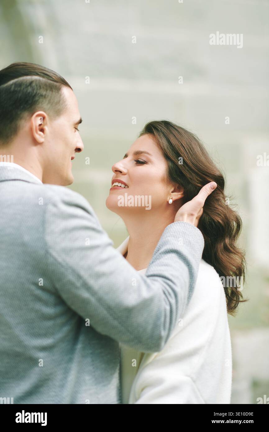 Couple romantique ferme portrait à l'extérieur avec l'homme touchant doucement les cheveux de femme, mariée élégante et mariée partageant moment intime pendant le jour du mariage dans cha Banque D'Images