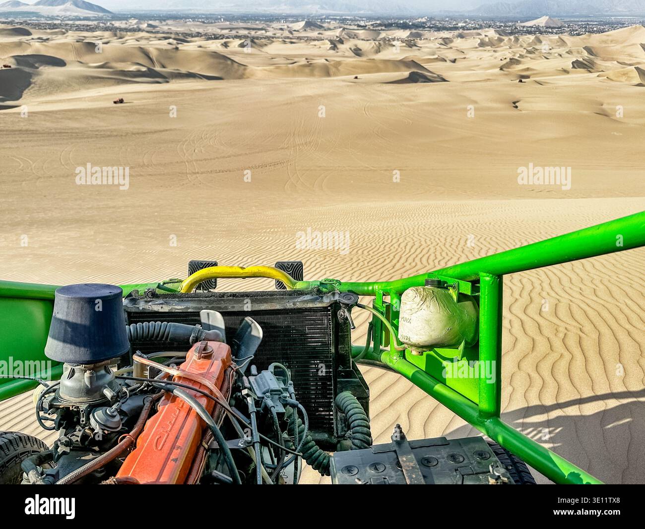 Les immenses dunes de sable du désert de Huacachina sont visibles sur les entretoises métalliques vert vif d'un buggy dunaire. Banque D'Images