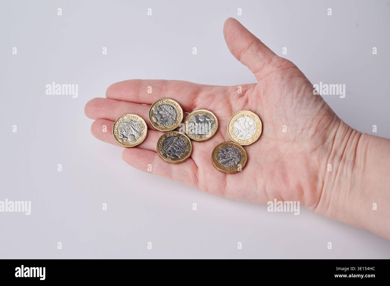 Les pièces de la livre britannique sont placées dans une main montrant clairement leurs détails. Banque D'Images