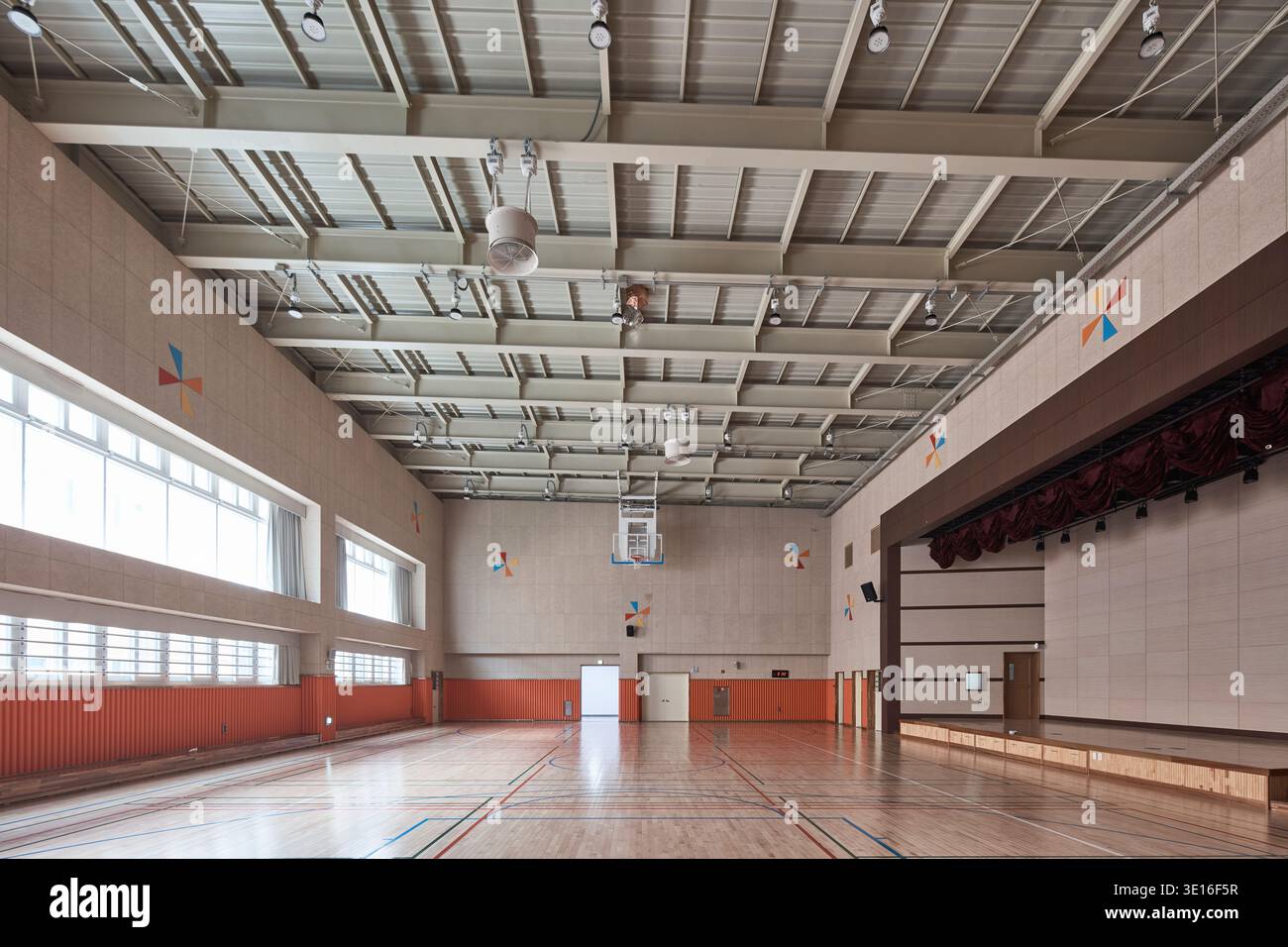 Gymnase scolaire vide avec sol poli et scène. Banque D'Images