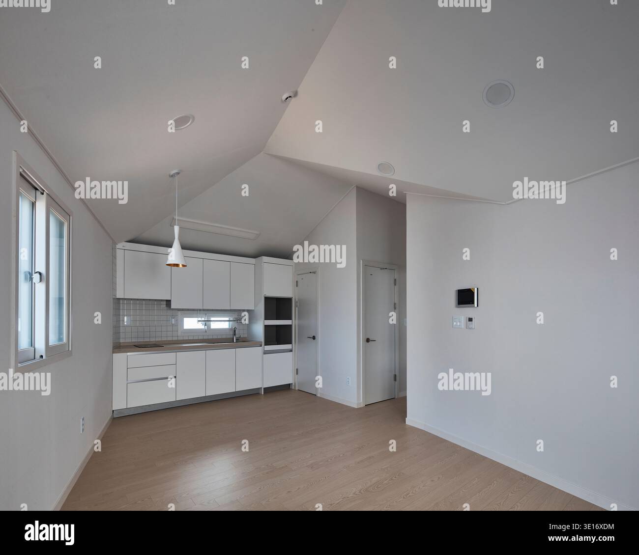 Cuisine blanche lumineuse avec surfaces propres et lumière naturelle. Banque D'Images