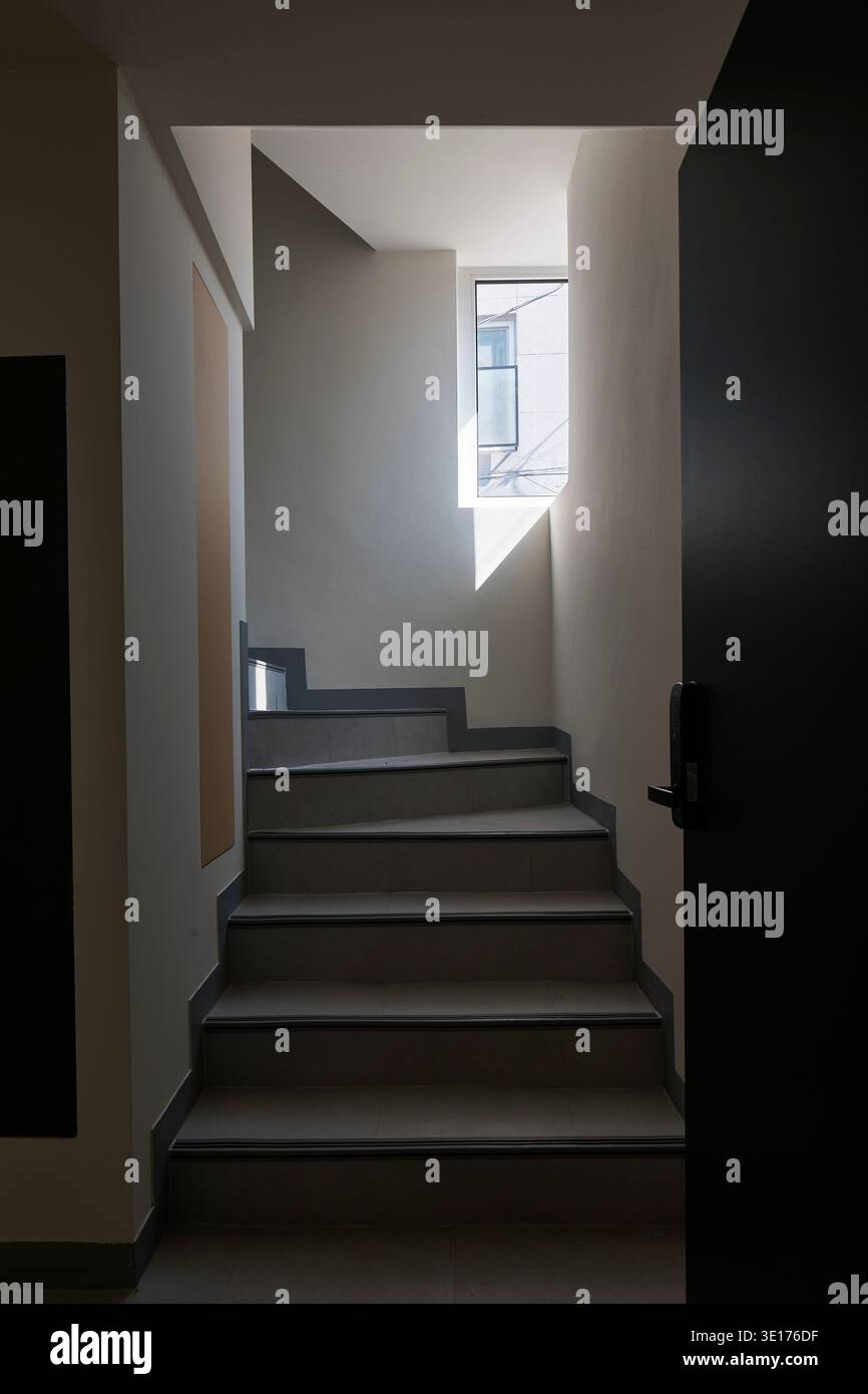 Hall d'escalier sombre dans un intérieur résidentiel minimal. Banque D'Images