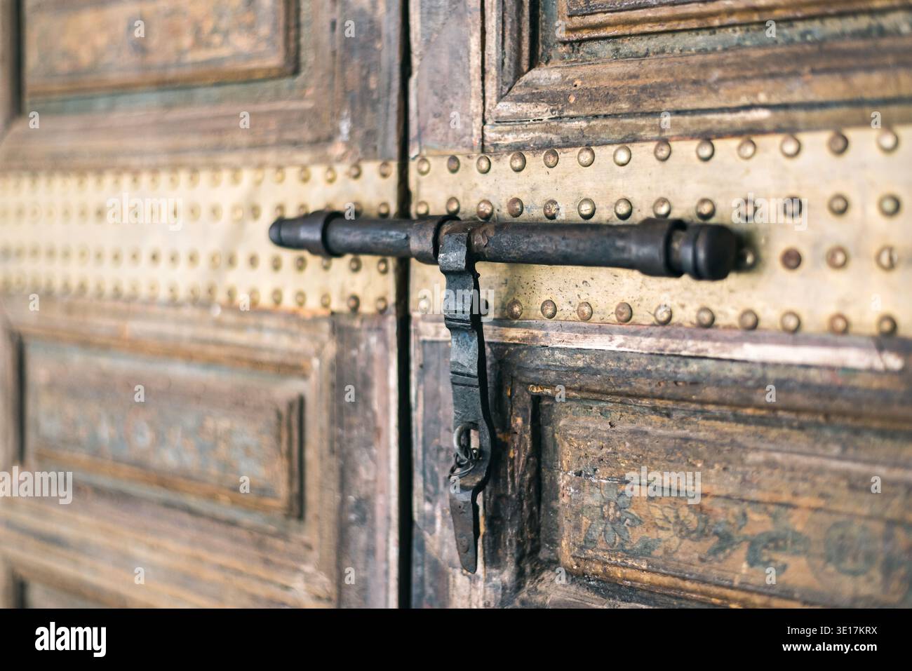 Gros plan d'une porte en bois traditionnelle à Marrakech, au Maroc, mettant en évidence des sculptures complexes et des travaux en métal. La conception met en valeur la riche histoire et Cu Banque D'Images