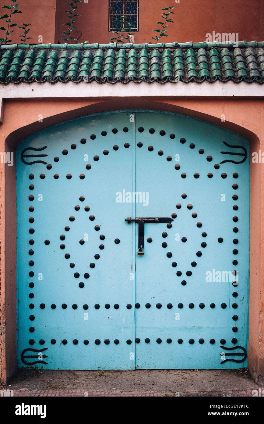 Vue détaillée d'une porte marocaine traditionnelle à Marrakech, caractérisée par des teintes bleues vibrantes et des motifs géométriques ornés, reflétant la richesse culturelle Banque D'Images