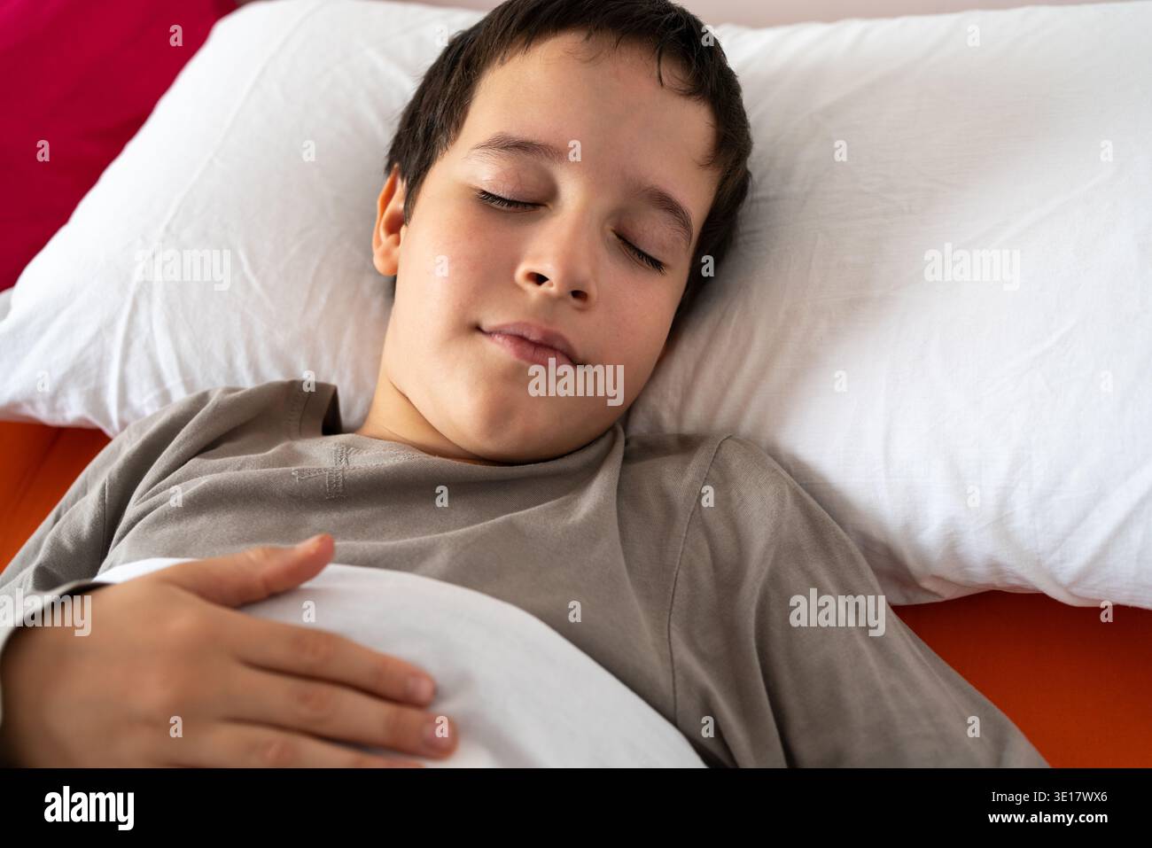 D'en haut de la récolte anonyme mâle en pyjama couché dans le lit sous une couverture chaude et dormant à la chambre Banque D'Images
