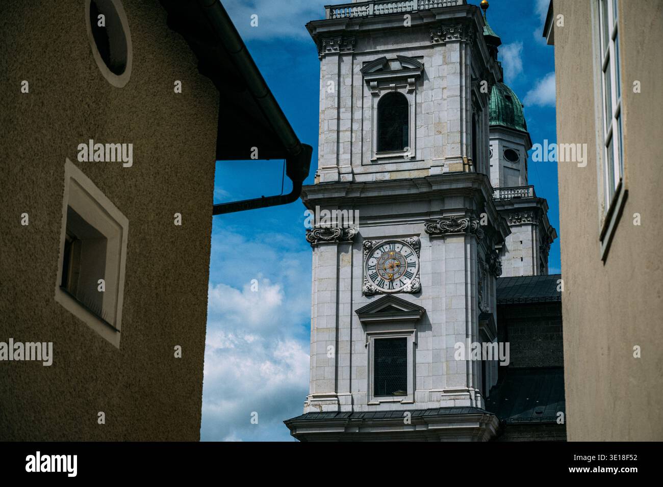 Tour de la cathédrale de Salzbourg avec cadran d'horloge vue entre les vieux bâtiments par une journée ensoleillée Banque D'Images