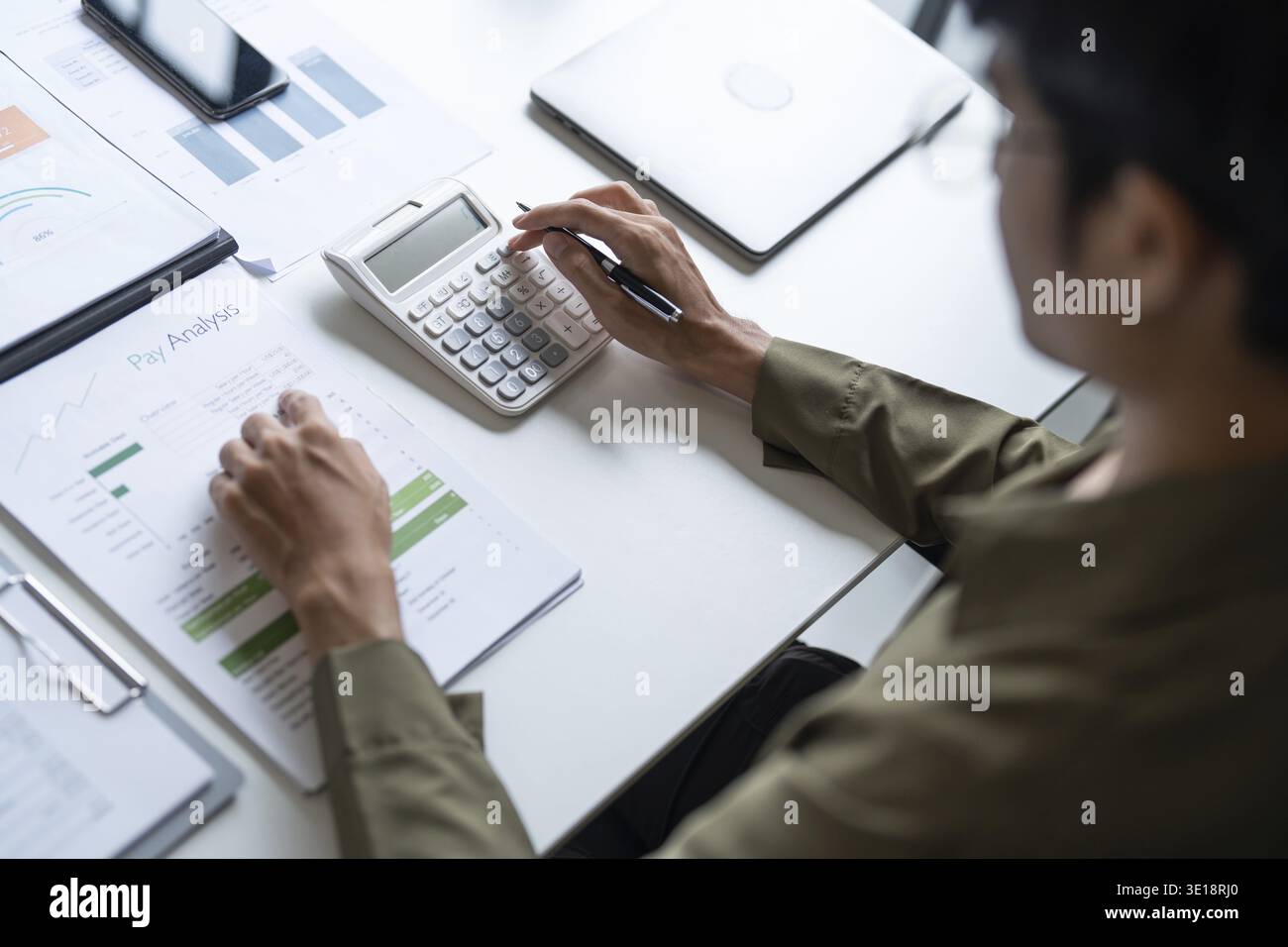 Professionnel masculin utilisant la calculatrice pour l'analyse du budget d'entreprise Banque D'Images