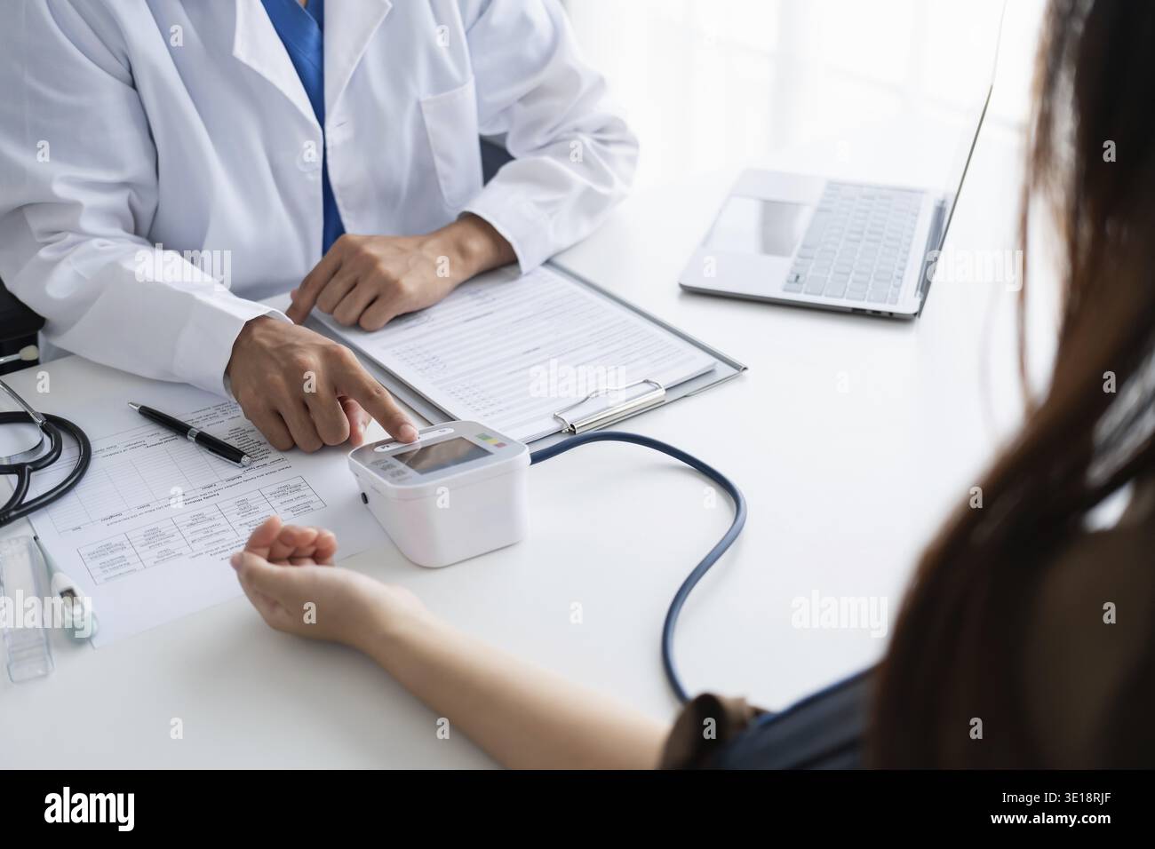 Médecin vérifiant la pression artérielle du patient. Les soins de santé mesurant la pression artérielle du patient Banque D'Images