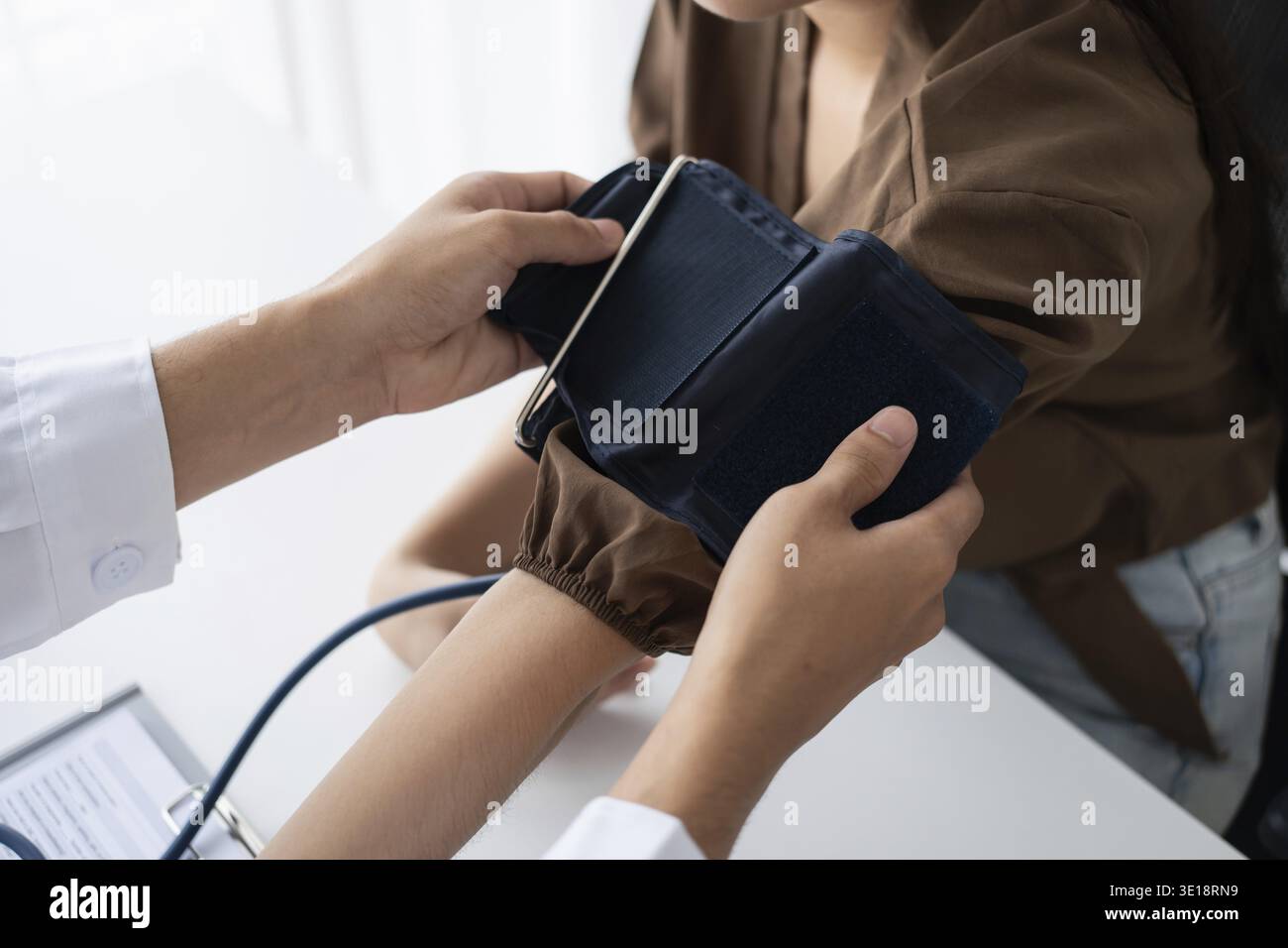 Médecin vérifiant la pression artérielle du patient. Les soins de santé mesurant la pression artérielle du patient Banque D'Images