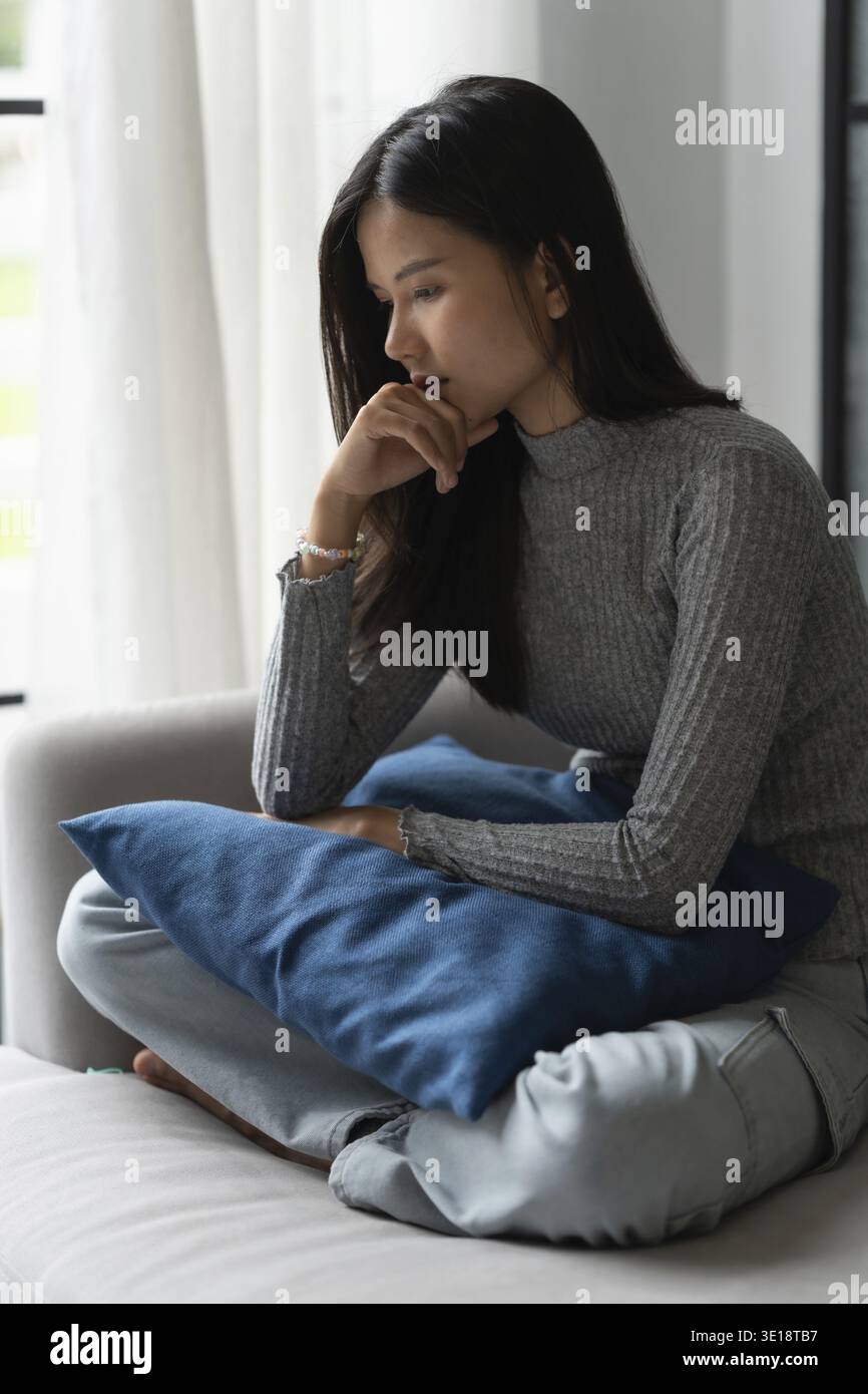 Jeune femme asiatique se sentant seule triste malade stressée sur Sofa at Home Alone pour Healthcare Wellness Lifestyle Banque D'Images