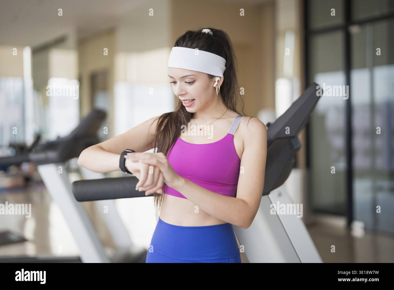 Jeune femme hispanique Gen Z dans les vêtements de sport vérifiant Smartwatch Health App après l'entraînement de gymnastique Banque D'Images