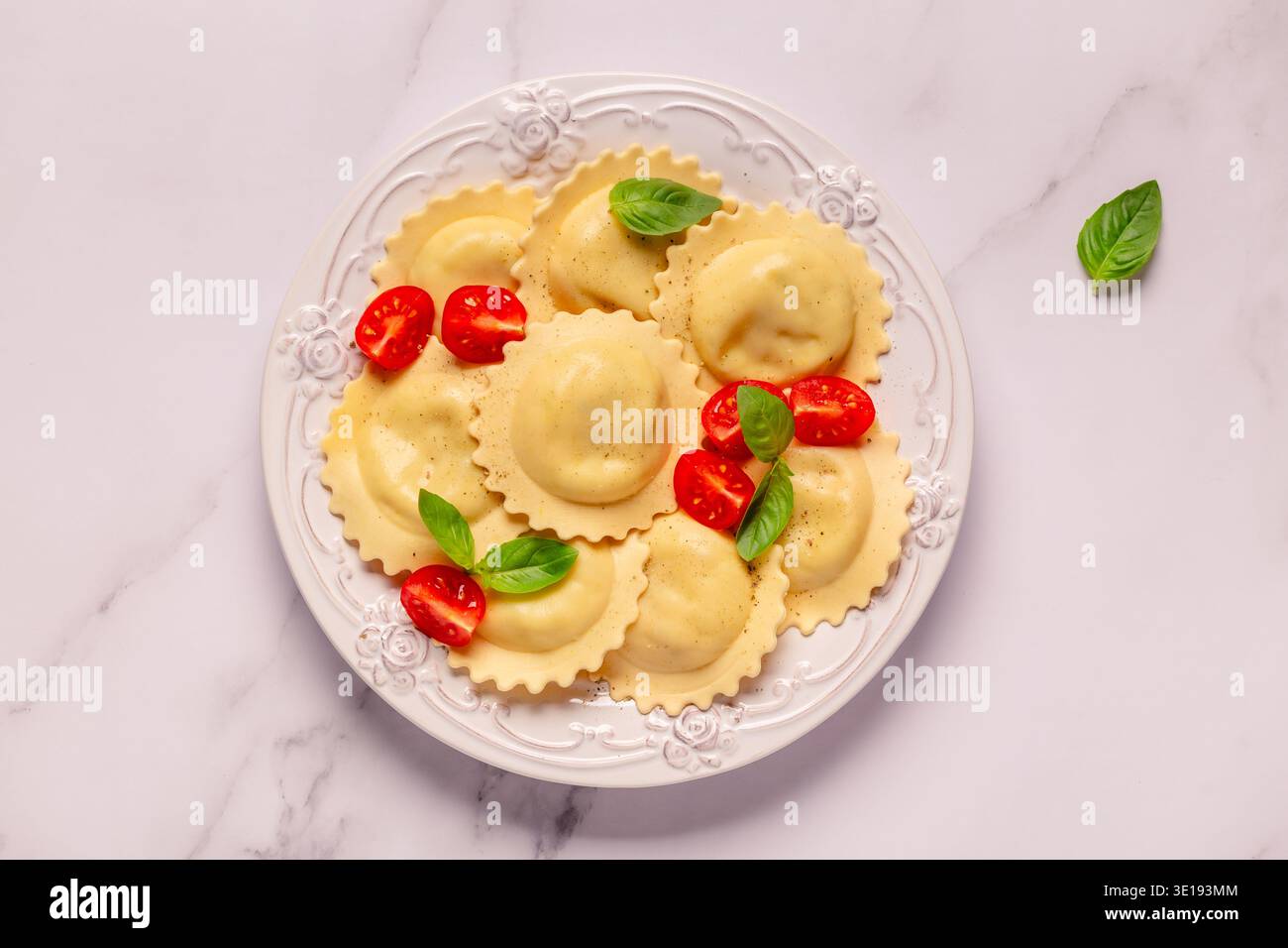 Raviolis avec sauce tomate et basilic sur assiette blanche. Banque D'Images