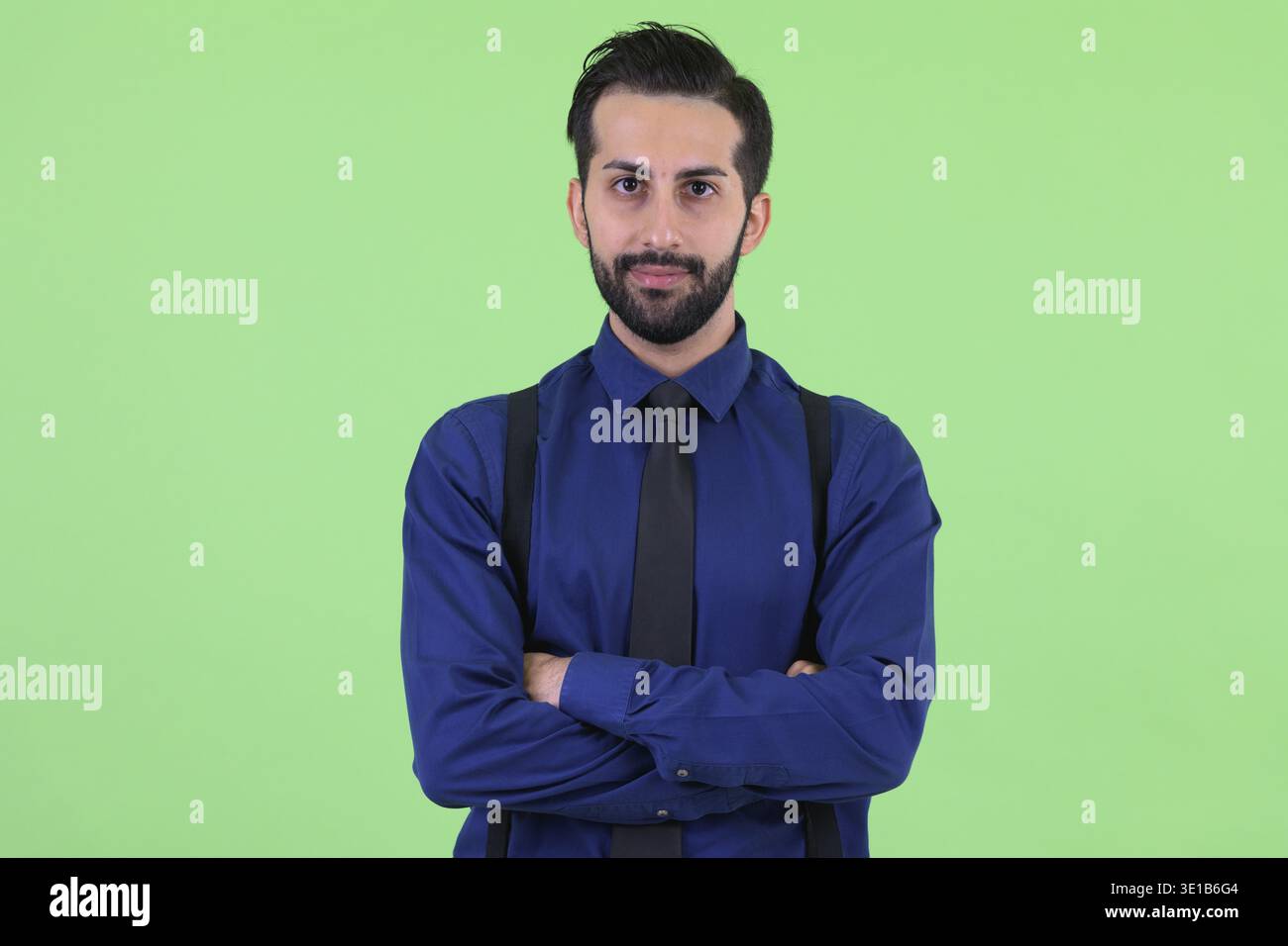 Studio shot du jeune bel homme d'affaires perse barbu sur fond vert Banque D'Images