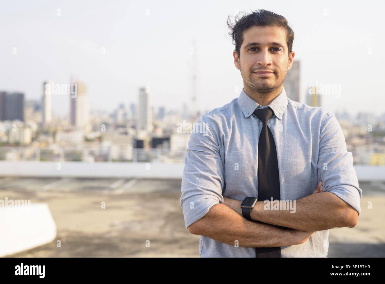 Portrait d'un jeune bel homme d'affaires iranien contre la vue de la ville Banque D'Images
